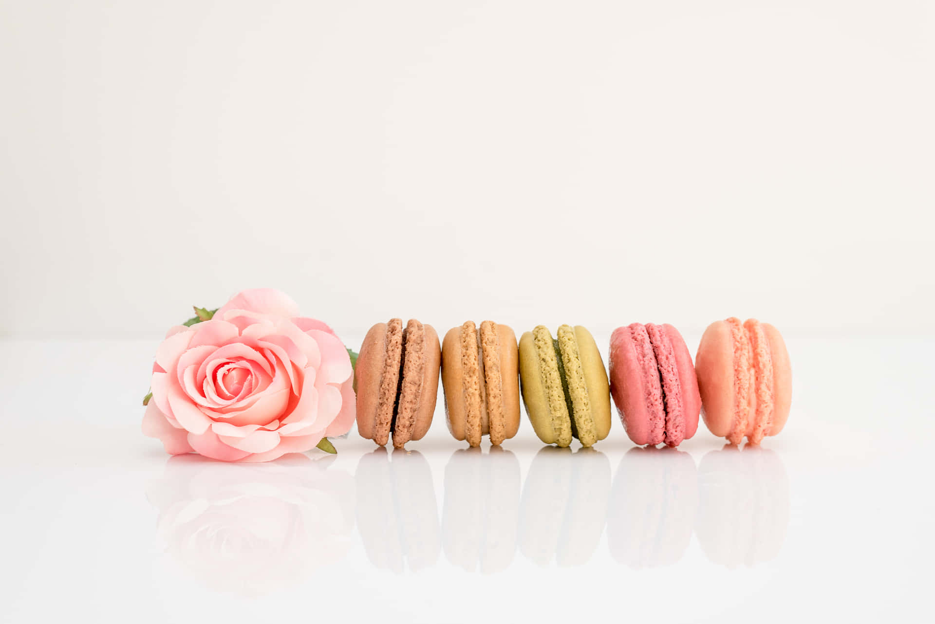 Ineiner Reihe Platzierte Macarons Mit Rose Wallpaper