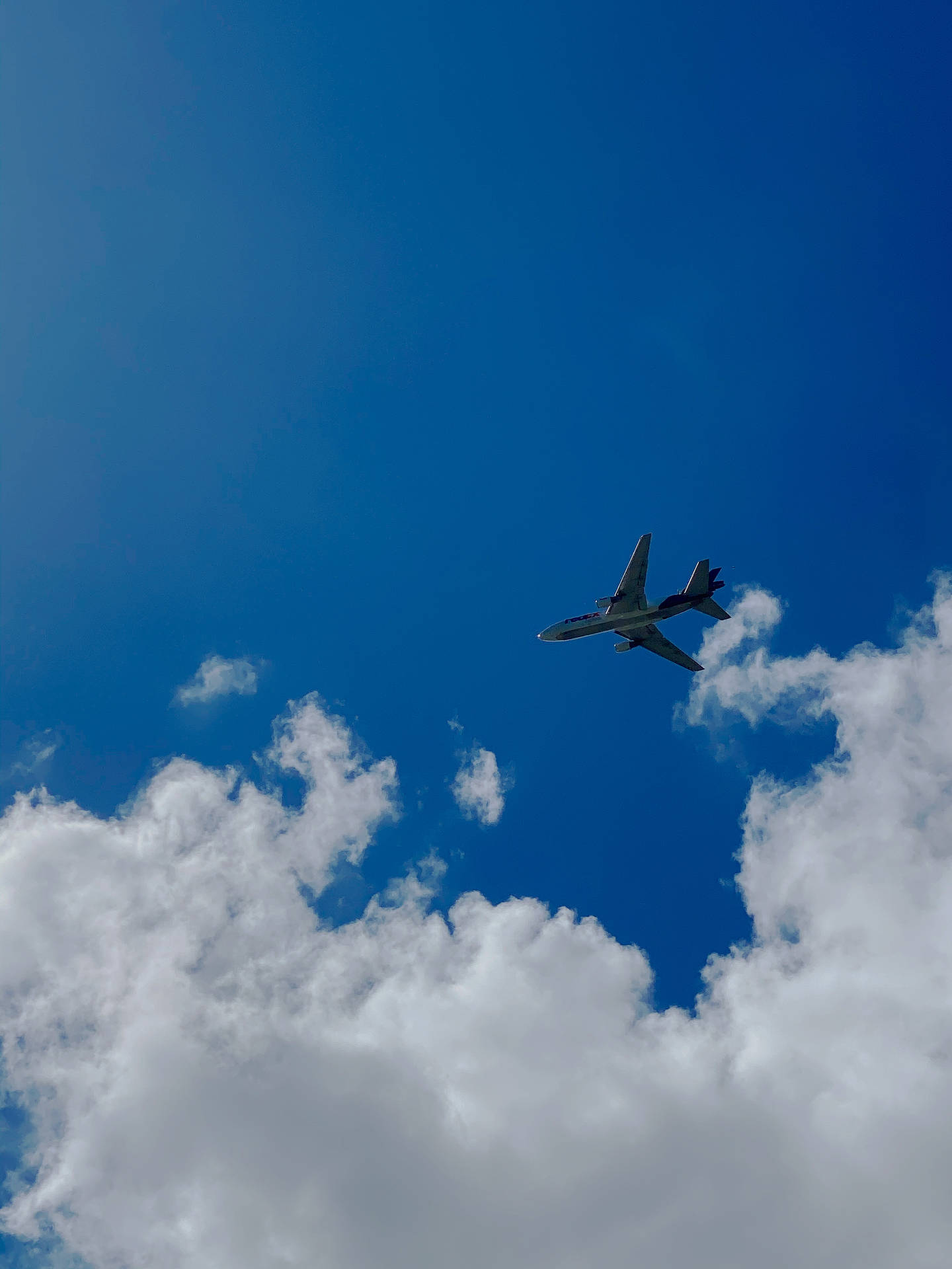 Plane Flying Under Azure Sky Wallpaper