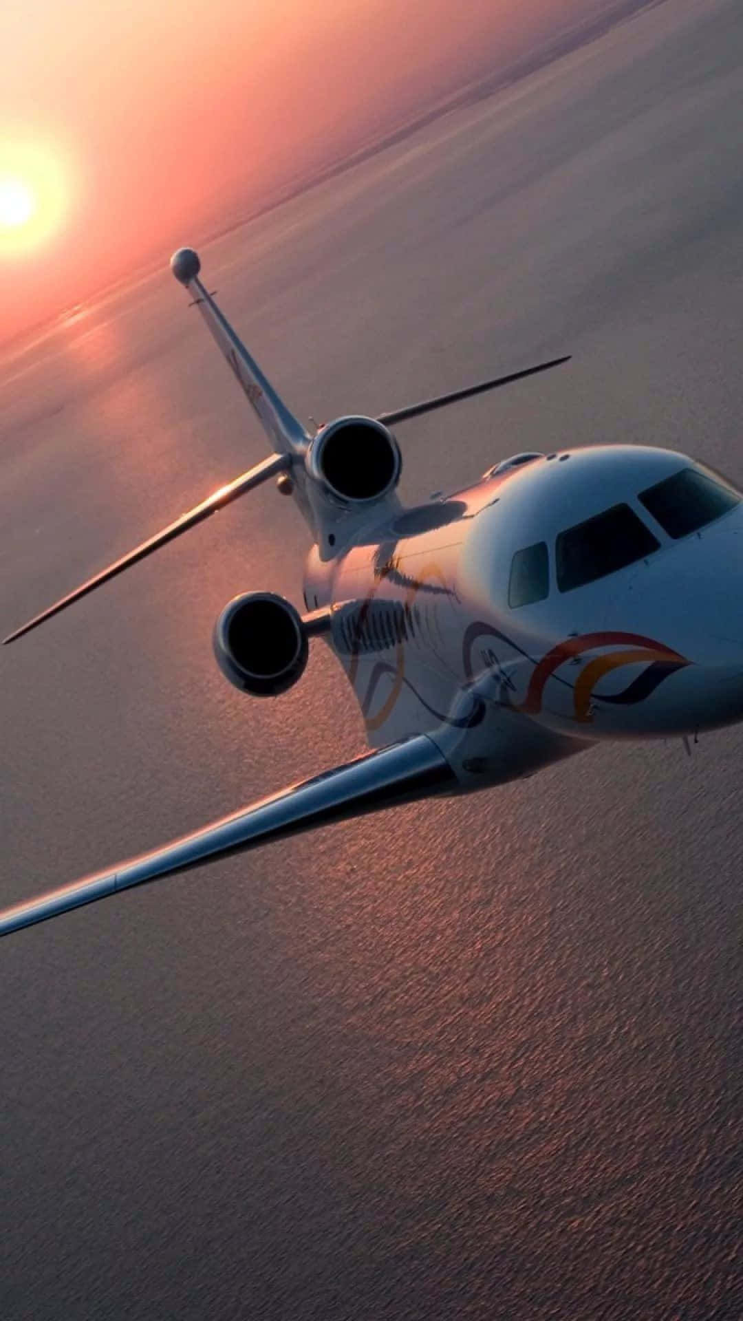 En privat jet flyver over havet ved solnedgang. Wallpaper