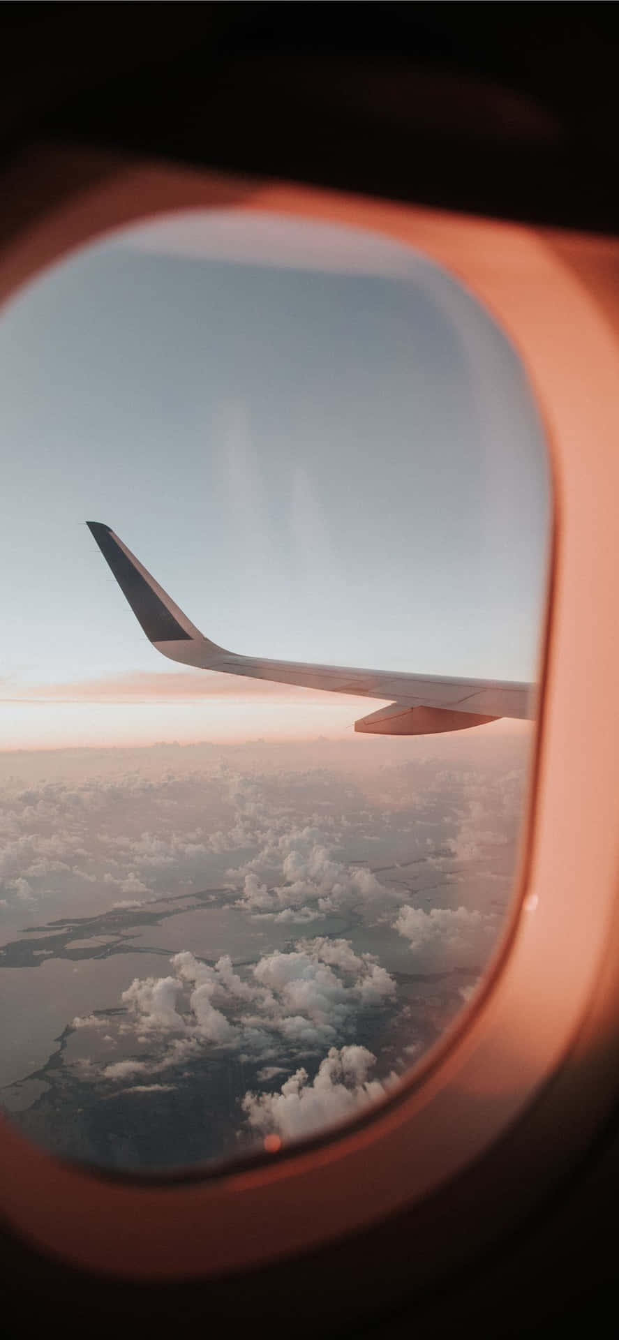 An Airplane Wing Seen Through An Airplane Window Wallpaper