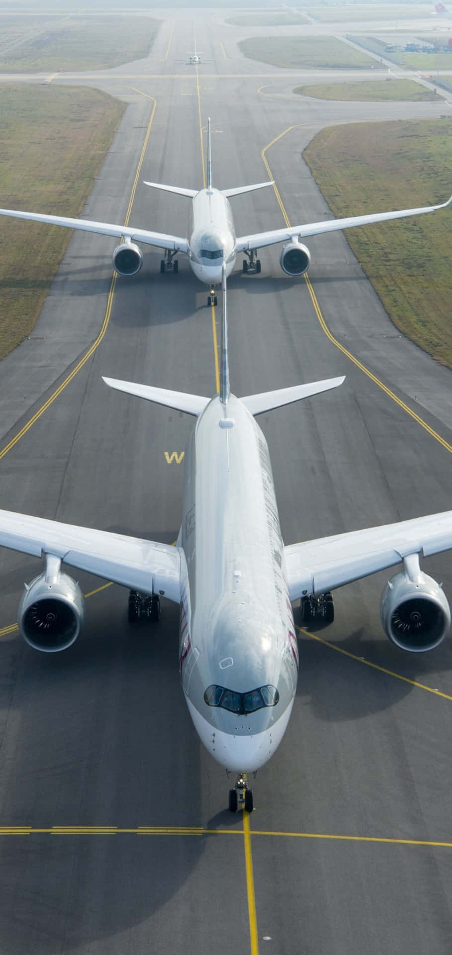 Two Large Airplanes On The Runway Wallpaper