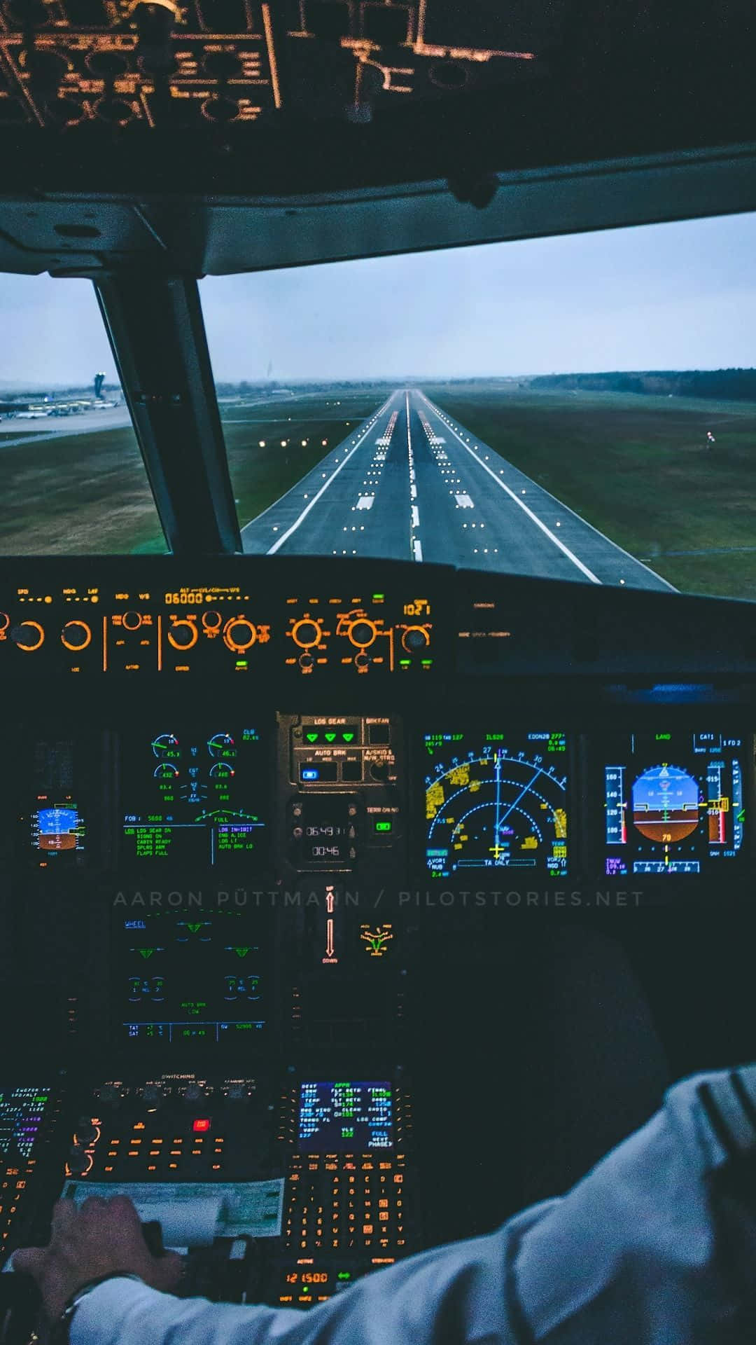En pilot sidder i cockpit på et fly. Wallpaper