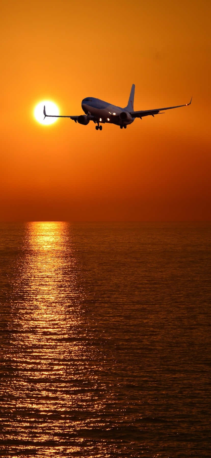 A Plane Flying Over The Ocean Wallpaper