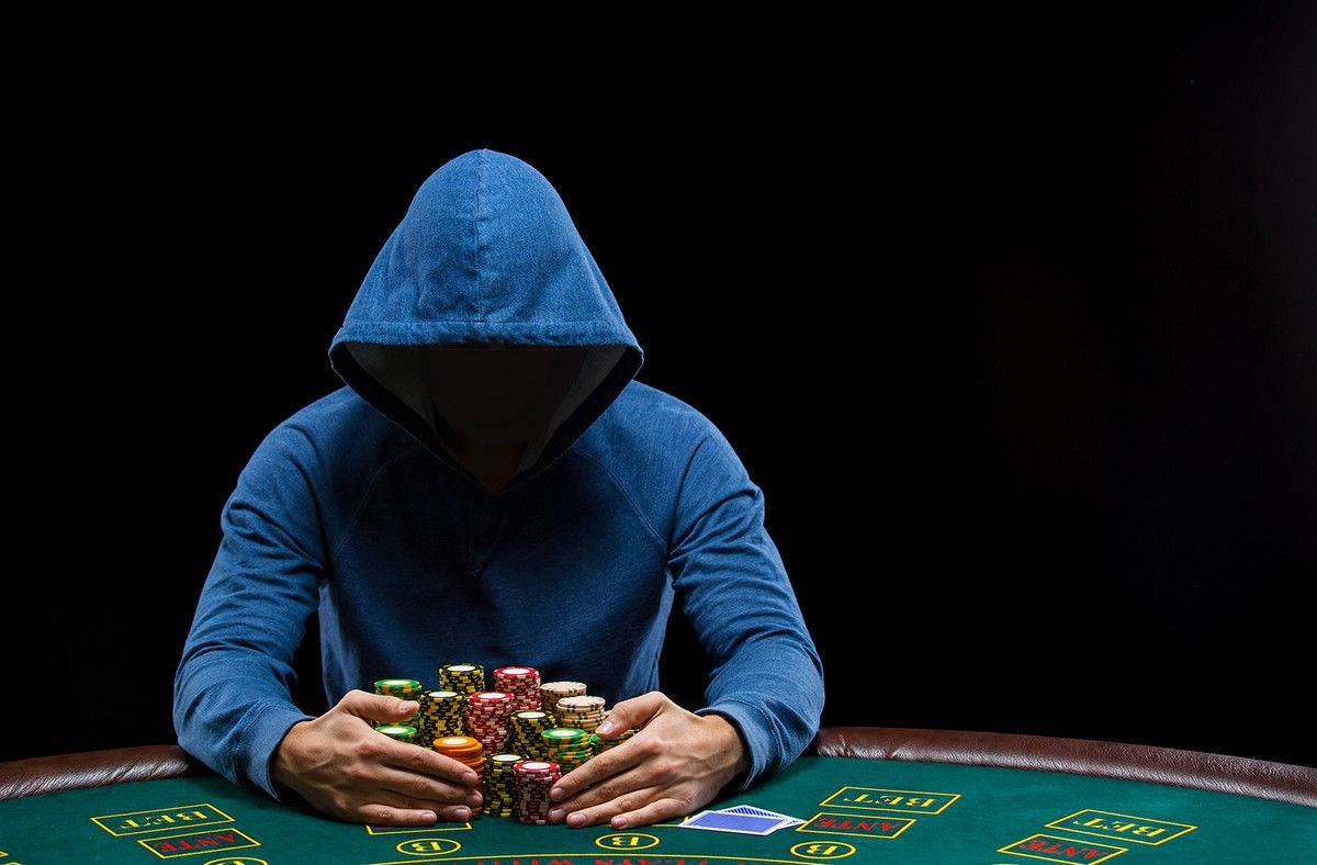 Jugadorcon Sudadera Azul Sentado En Una Mesa De Póker Baccarat. Fondo de pantalla