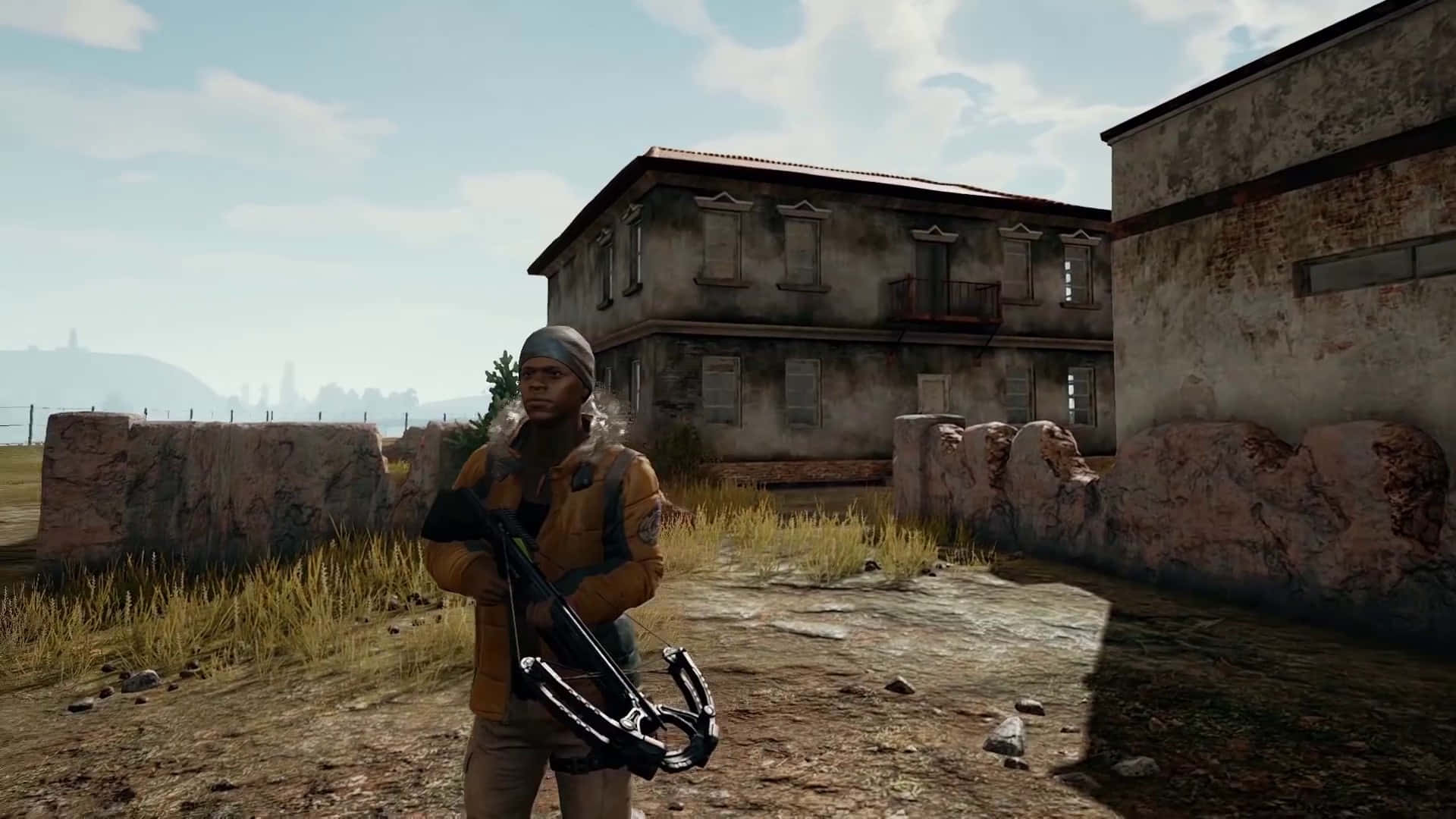 En mand med et gevær står foran et bygning. Wallpaper