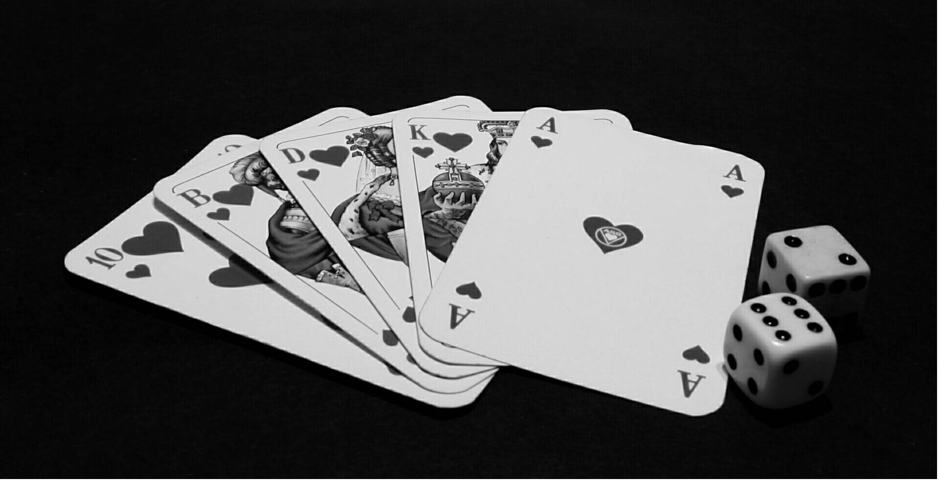 Фартовая или фортовая. Игральные карты. Игральные кости на черном фоне. Покерные карты. Игральные карты казино.