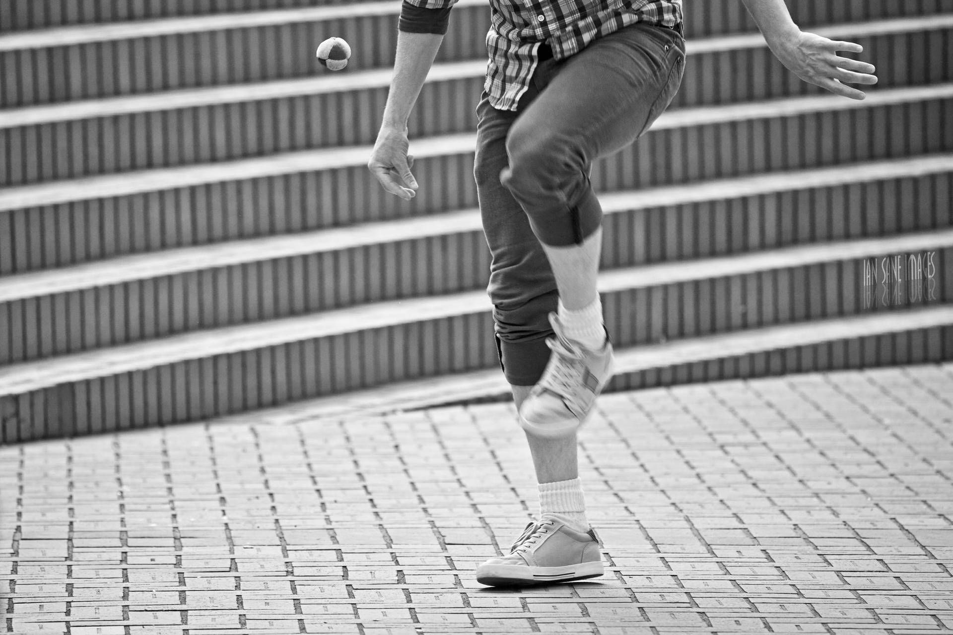 A Passionate Player Kicking Hacky Sack in Action Wallpaper