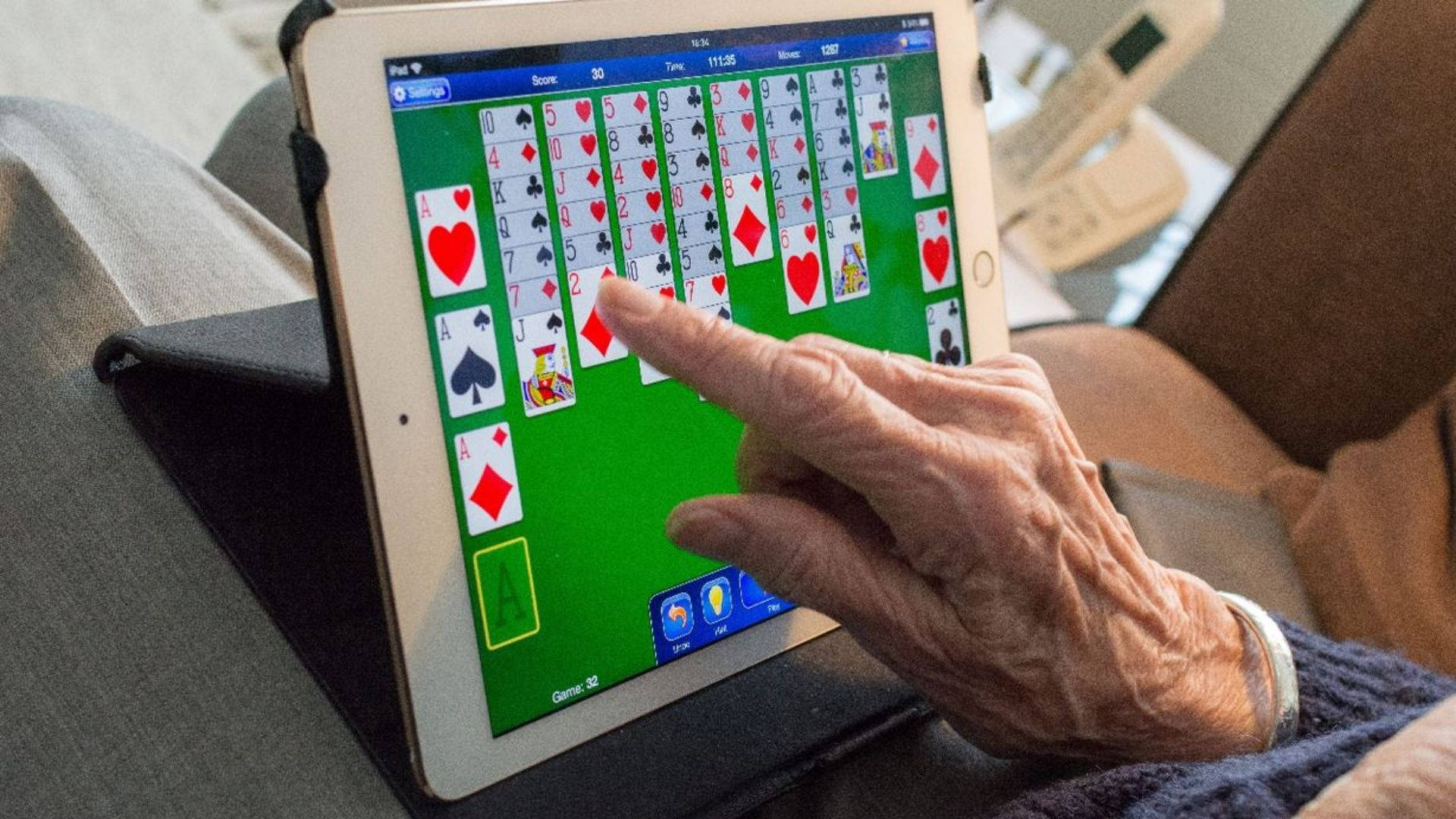 Playing Solitaire On A Tablet Wallpaper