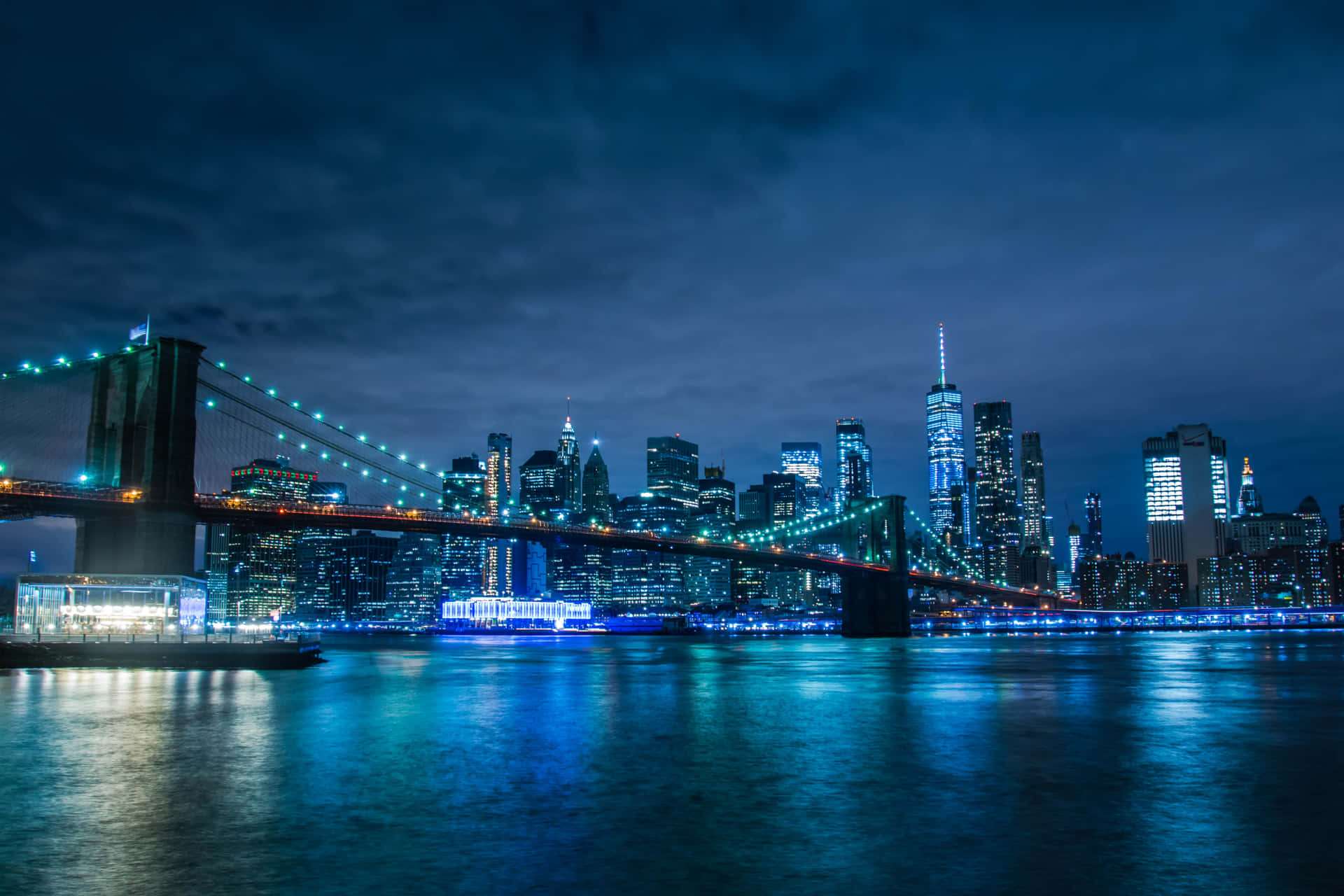 Puentede Brooklyn De Noche Con Las Luces De La Ciudad. Fondo de pantalla