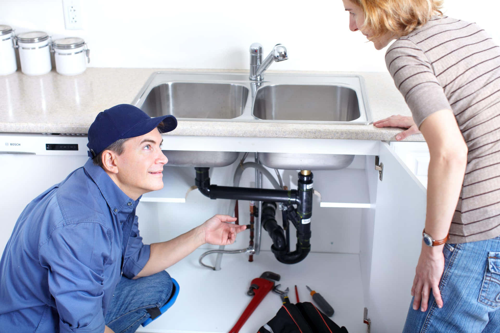 An expert plumber installing a new faucet in a modern kitchen