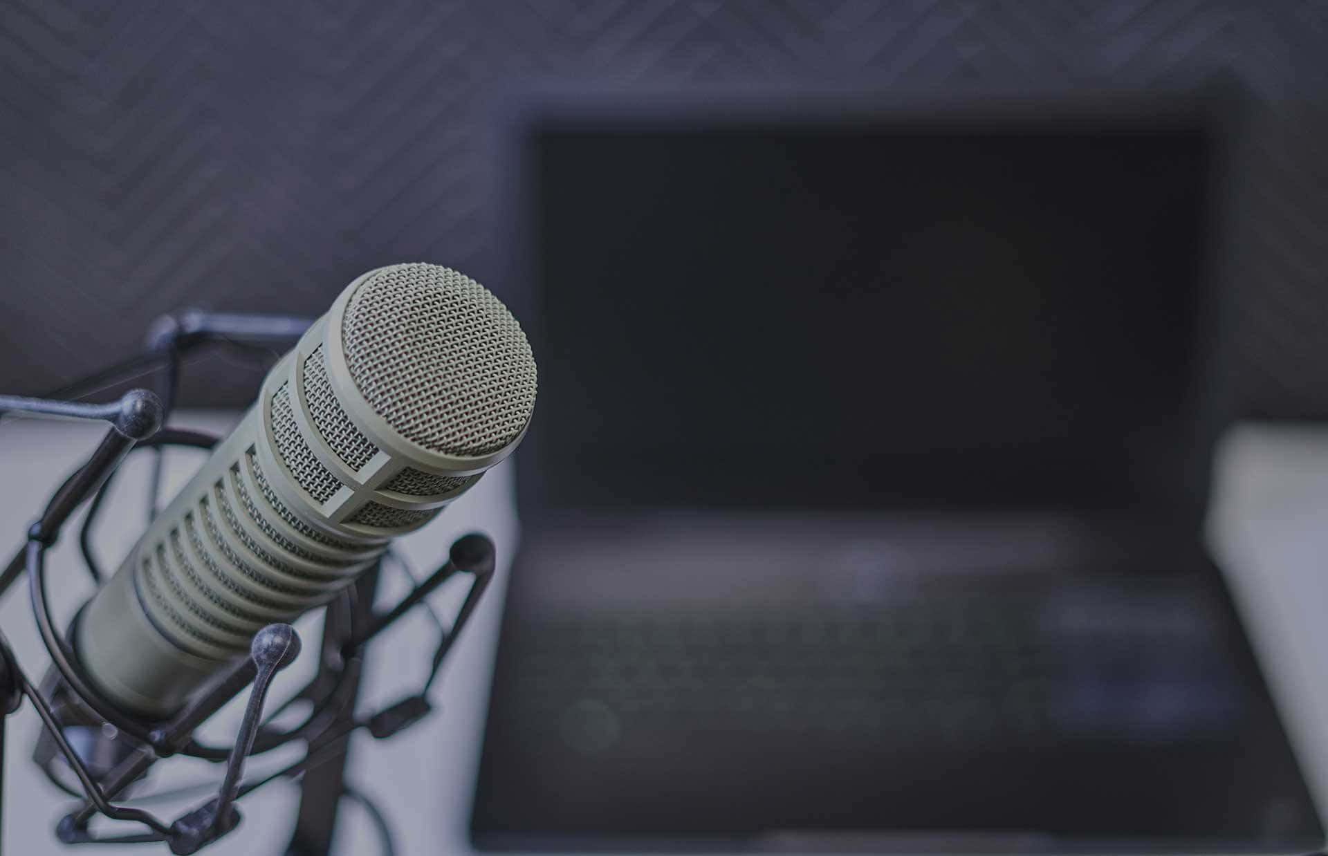 Sfondopaesaggio Con Microfono Per Podcast Sfocato Su Laptop