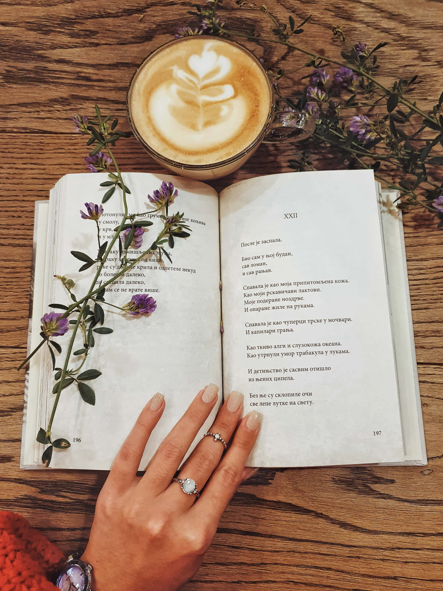 En kvinde der holder en bog og en kop kaffe Wallpaper