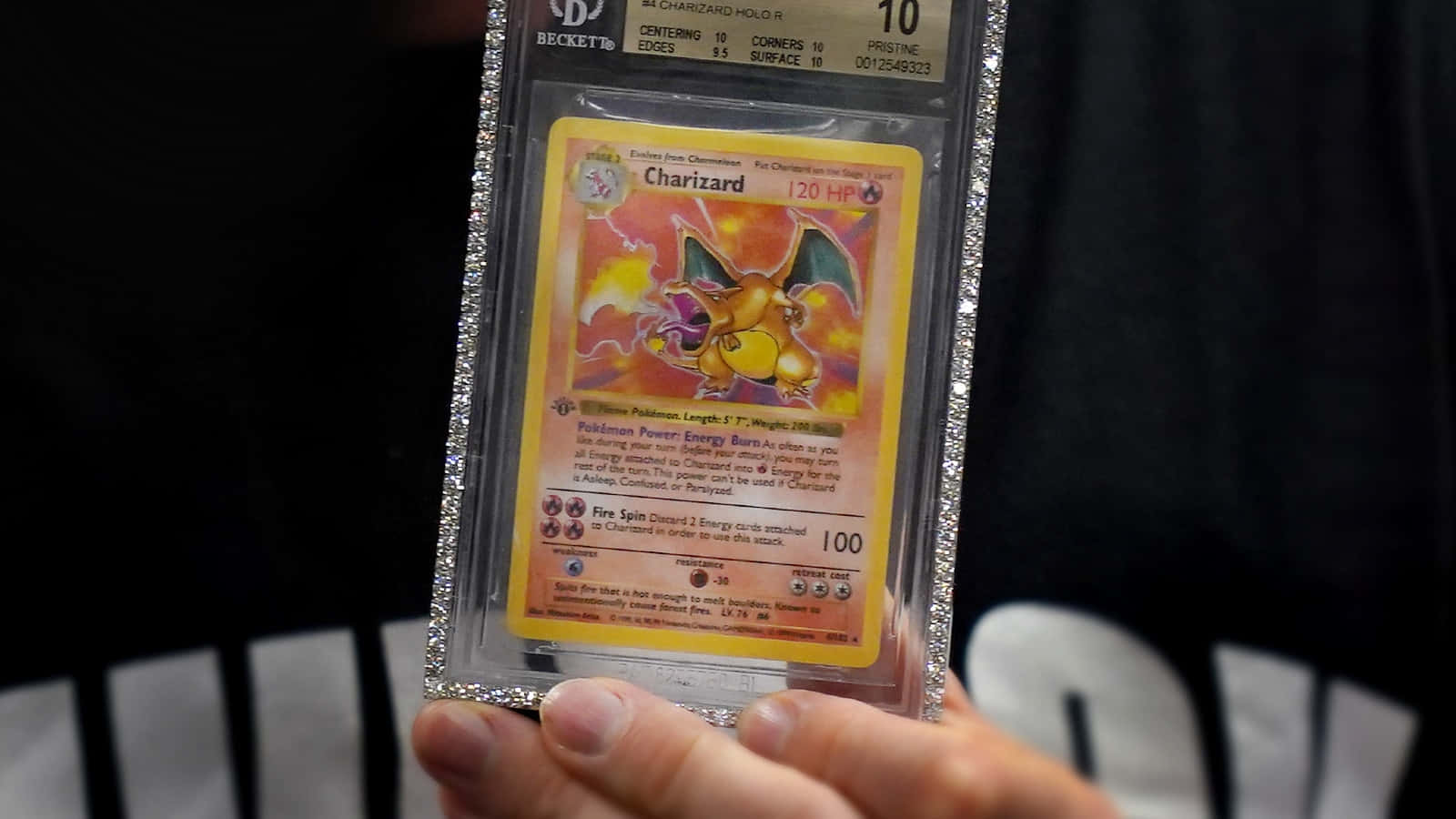 A Person Holding Up A Pokemon Card In A Cd Case