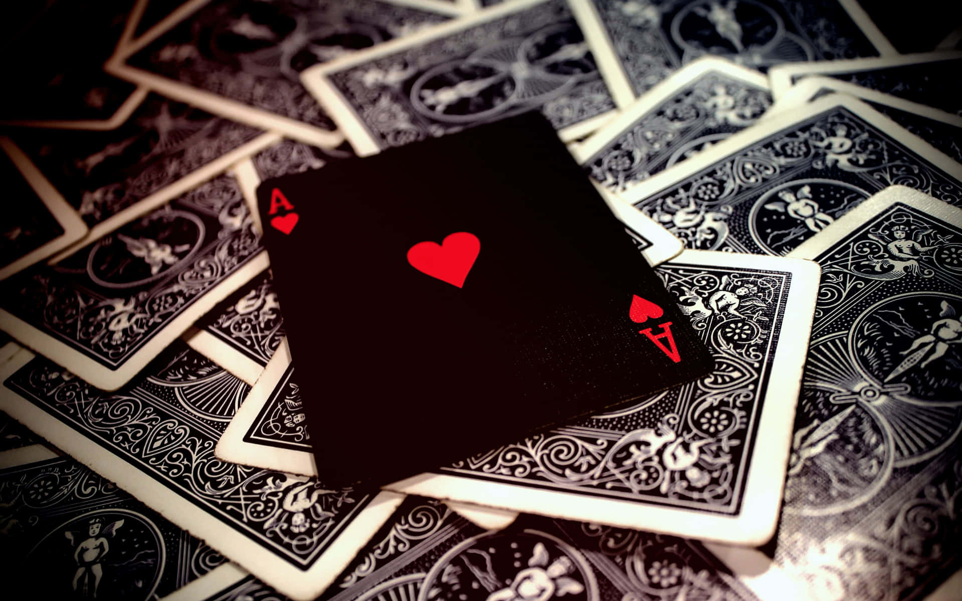 A Black Playing Card With A Red Heart On It
