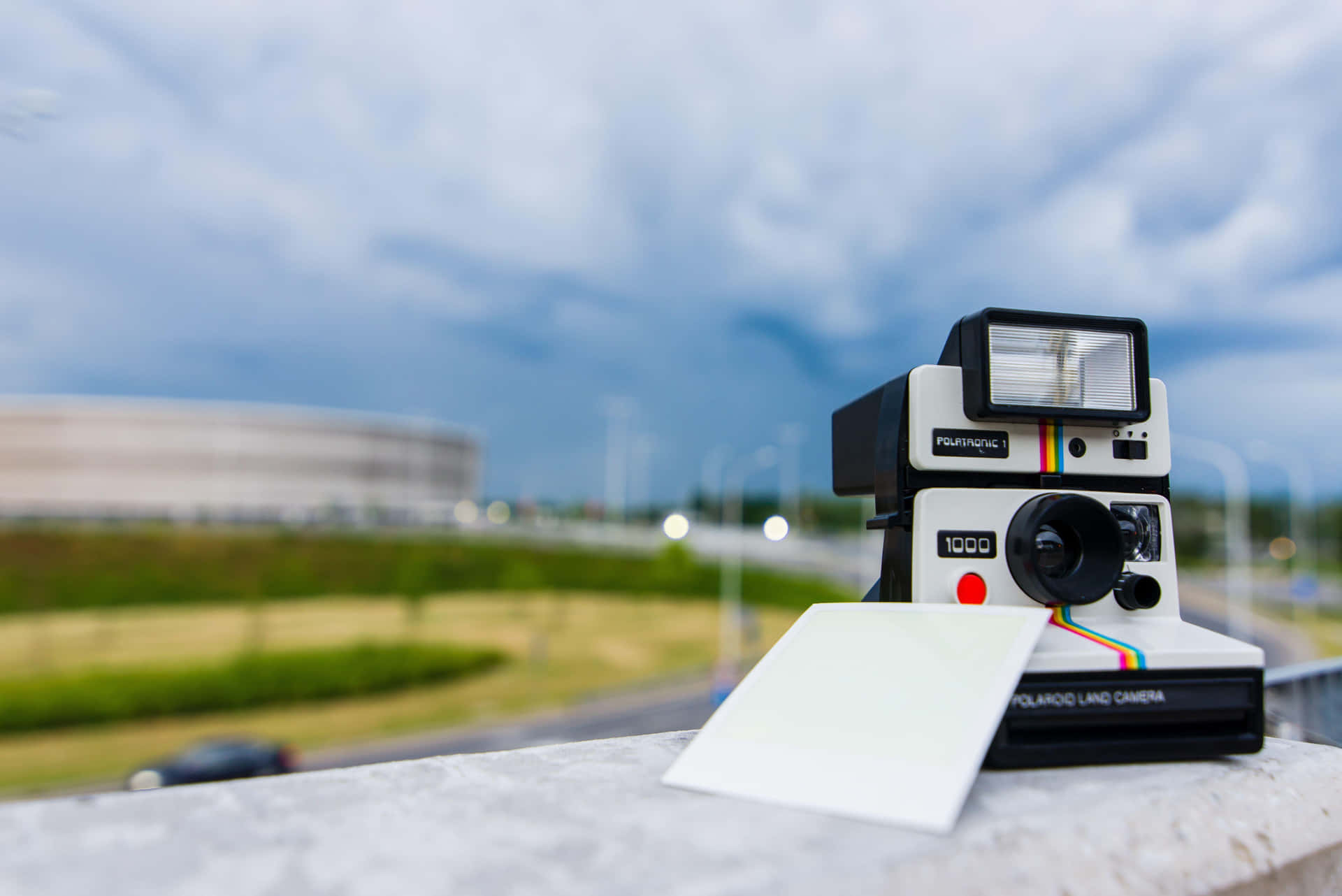 A Polaroid Camera Sits On A Ledge With A Note On It