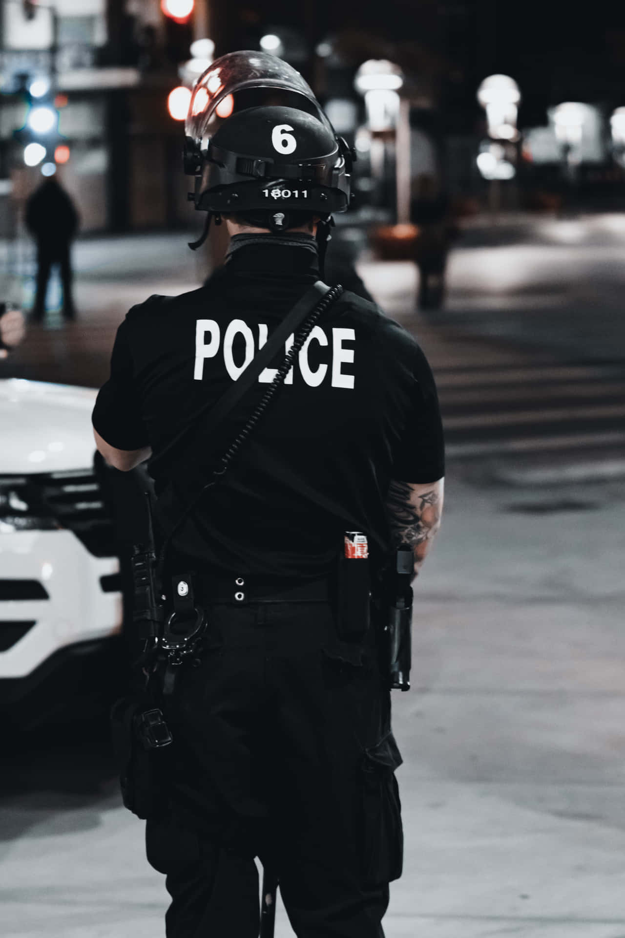 Police Officer Standing On The Street At Night Wallpaper