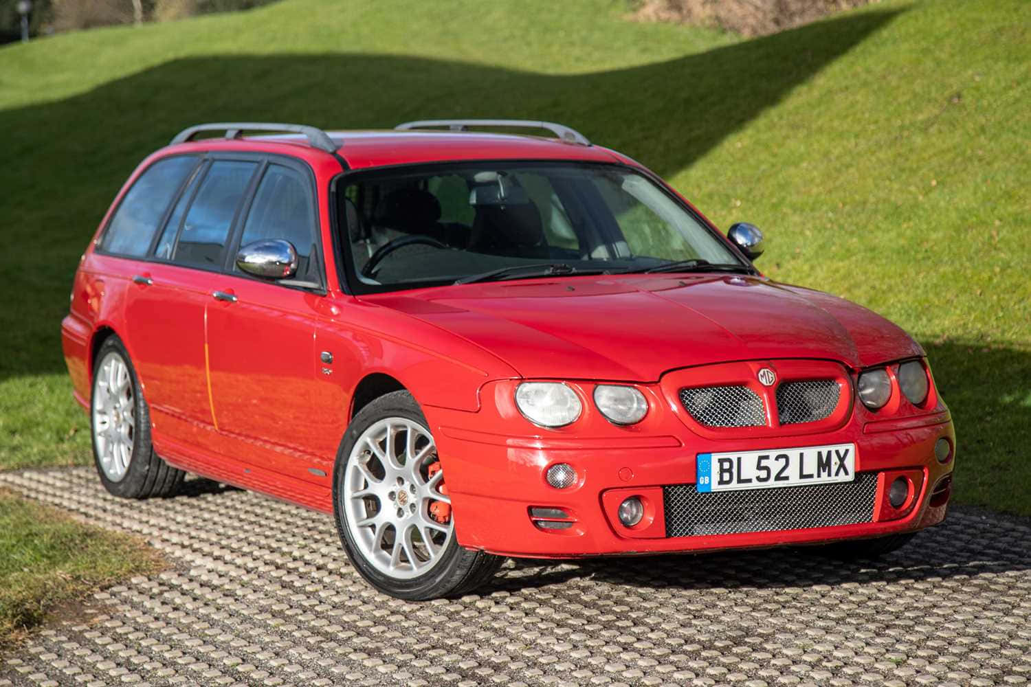 Polished Silver Mg Zt Luxury Sports Sedan Parked Outside Wallpaper