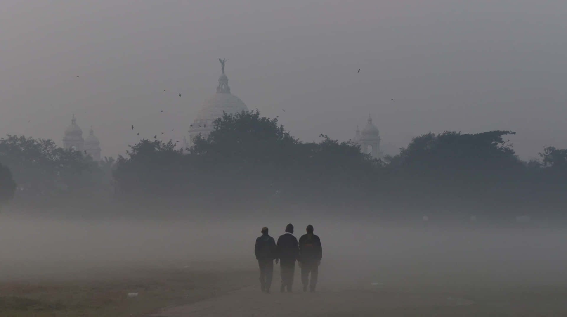 Treshombres Caminando En La Niebla Con Una Iglesia Al Fondo