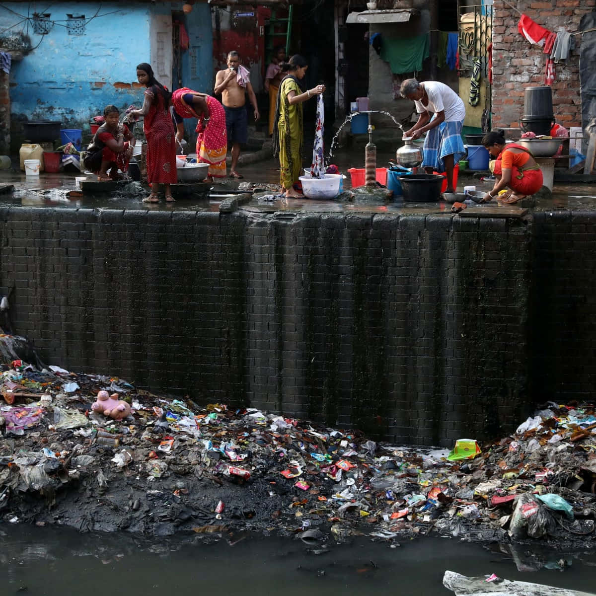 People Are Washing Their Clothes In A Slum