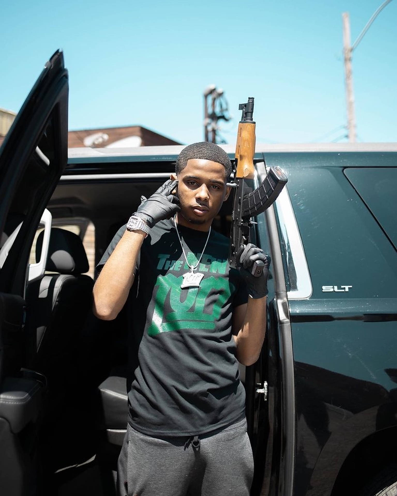 American Rapper Pooh Shiesty Posing with a Rifle Wallpaper