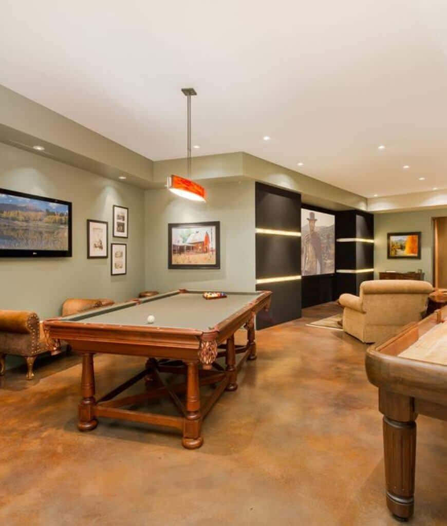 A Basement With A Pool Table And A Tv