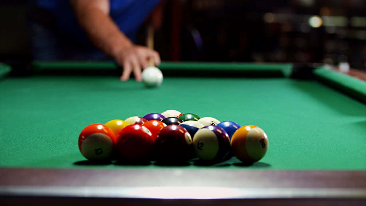 A Man Is Playing Billiards With Balls On A Table