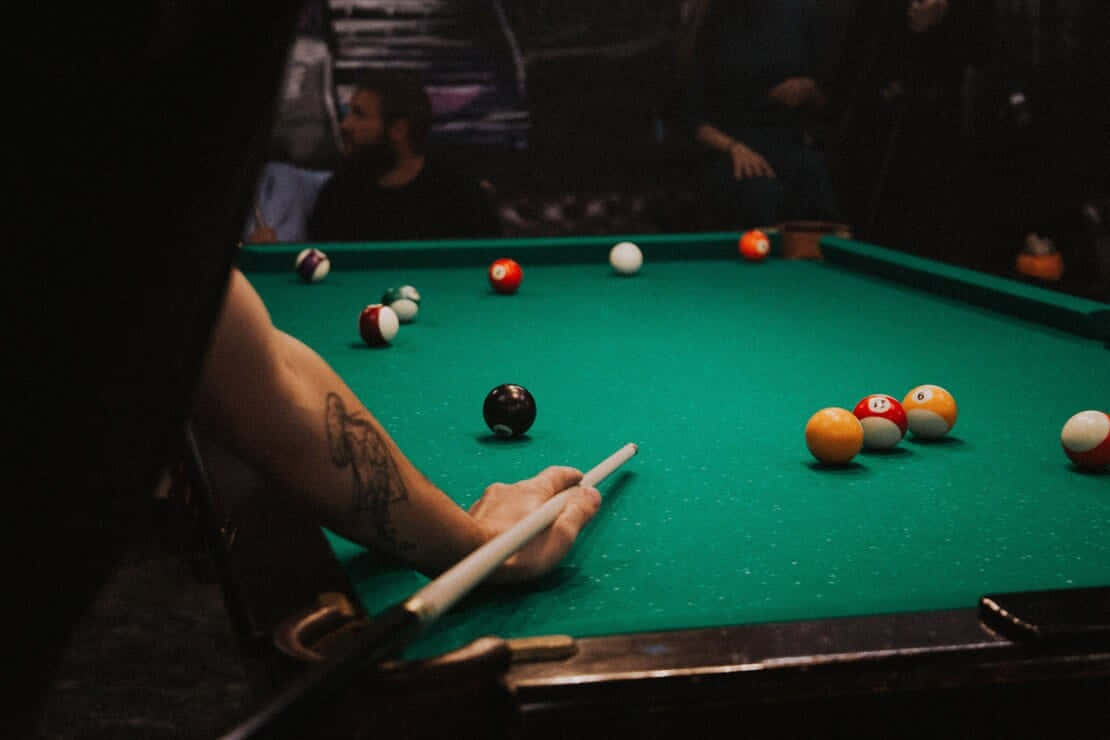 A Man Is Playing Pool With A Ball