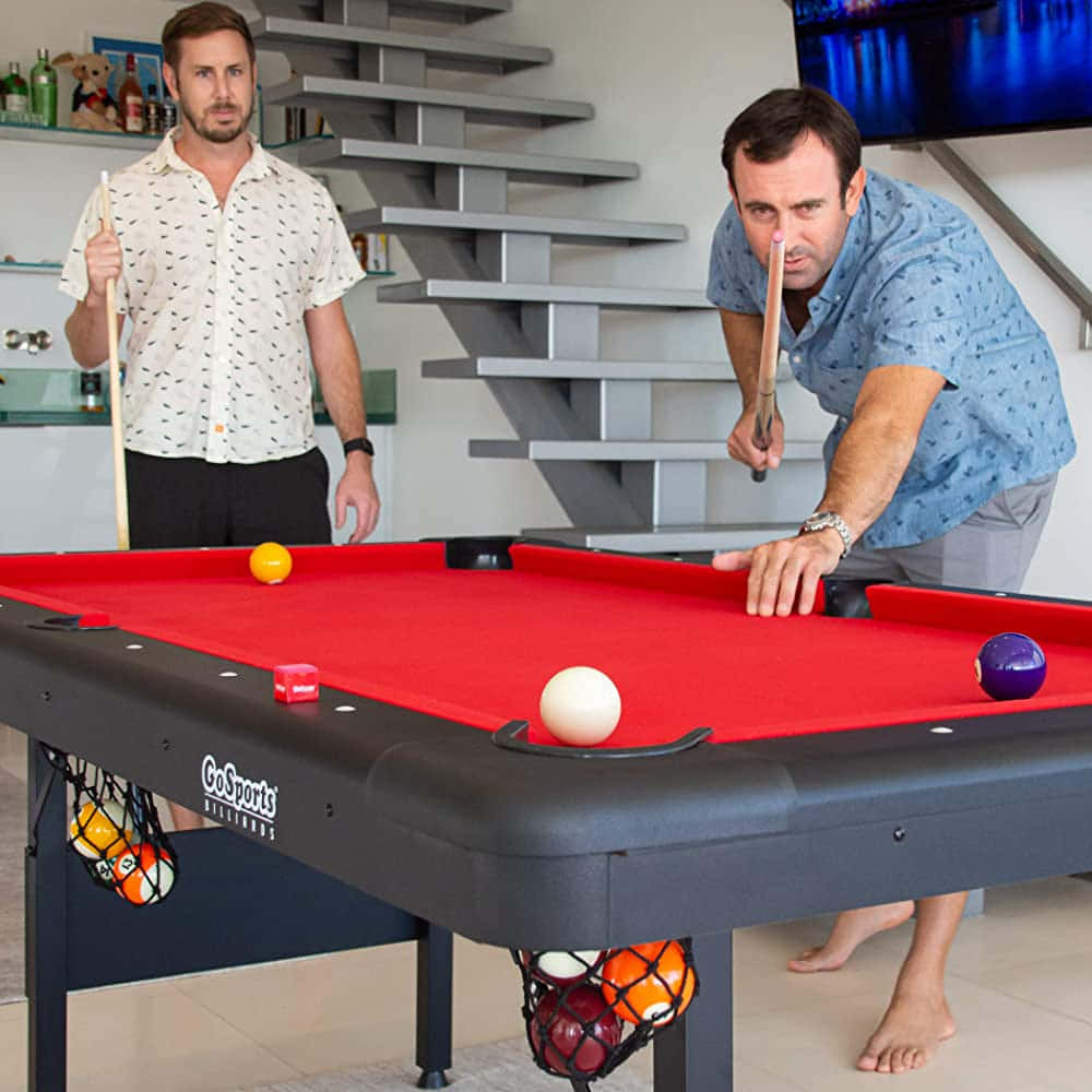 Two Men Playing Pool In A Living Room