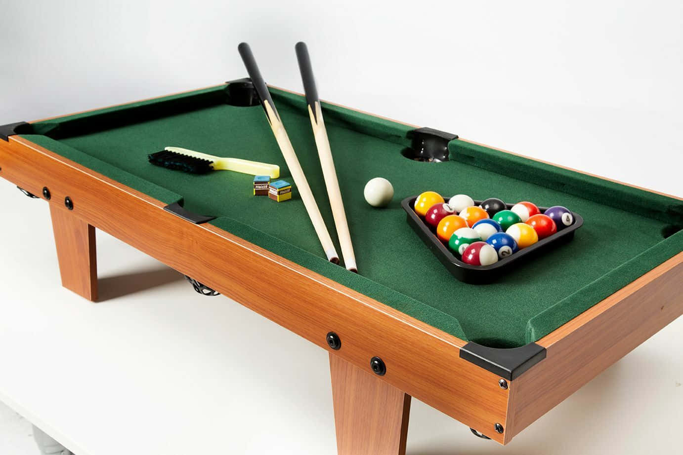 A Pool Table With Balls And Cues On Top