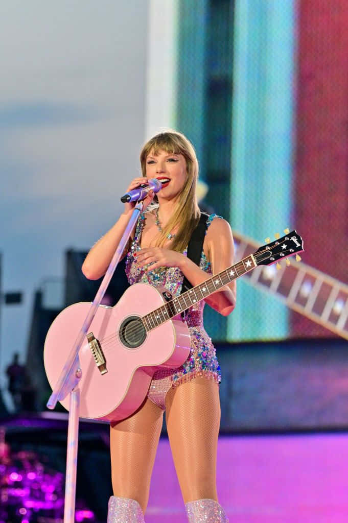 Pop Star Performancewith Pink Guitar Wallpaper