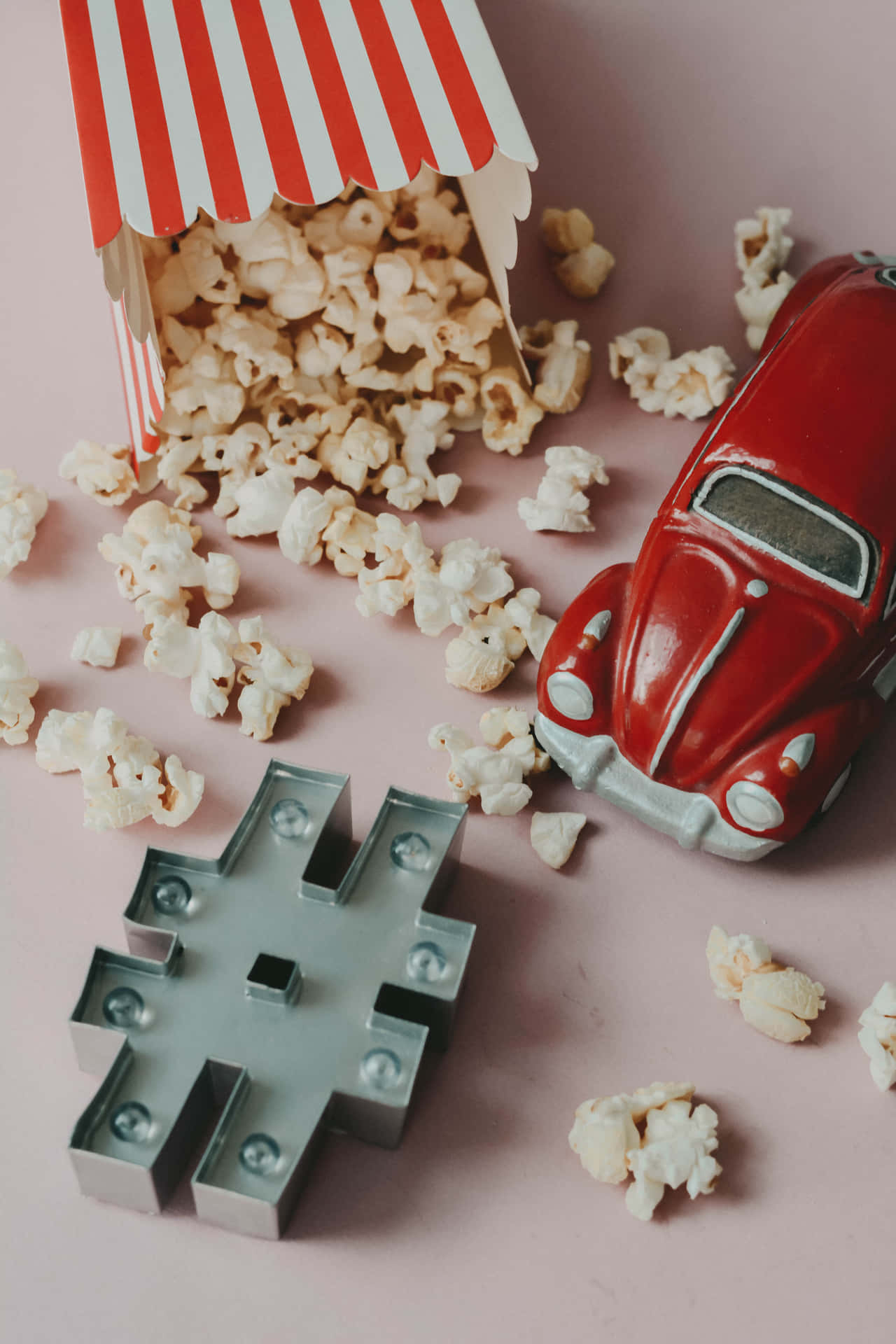 A Red Car And Popcorn Box On A Pink Background