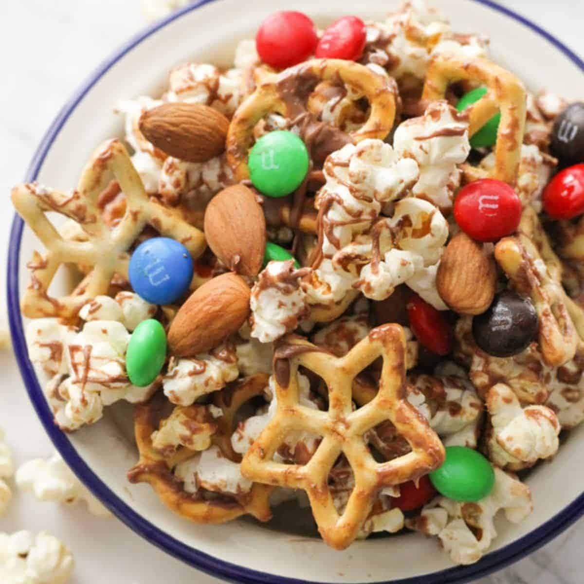 A Bowl Of Popcorn With Candy And Nuts