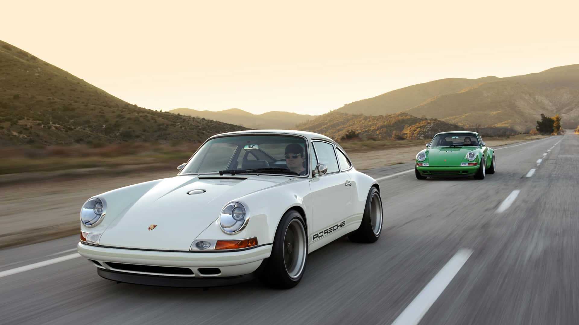 Sleek Porsche driving through a picturesque cityscape at dusk