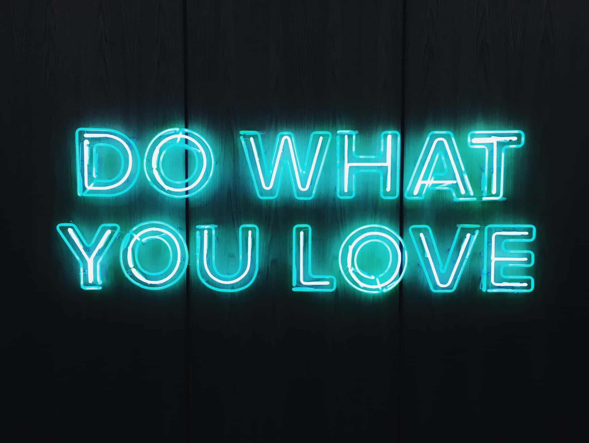 Gør hvad du elsker neon skilt på træ baggrund Wallpaper