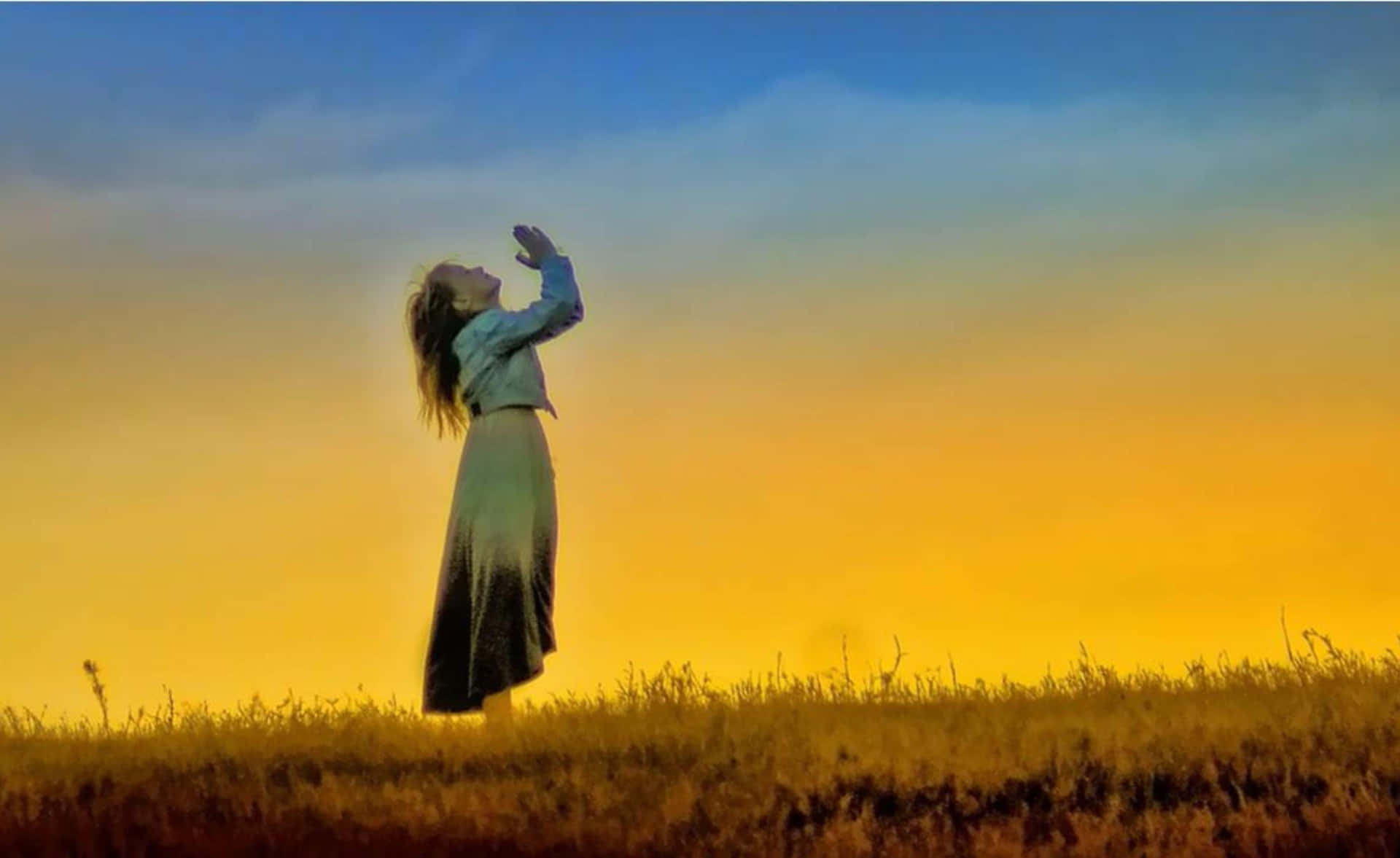 Einefrau Steht Auf Einem Feld Und Streckt Ihre Arme Nach Oben.