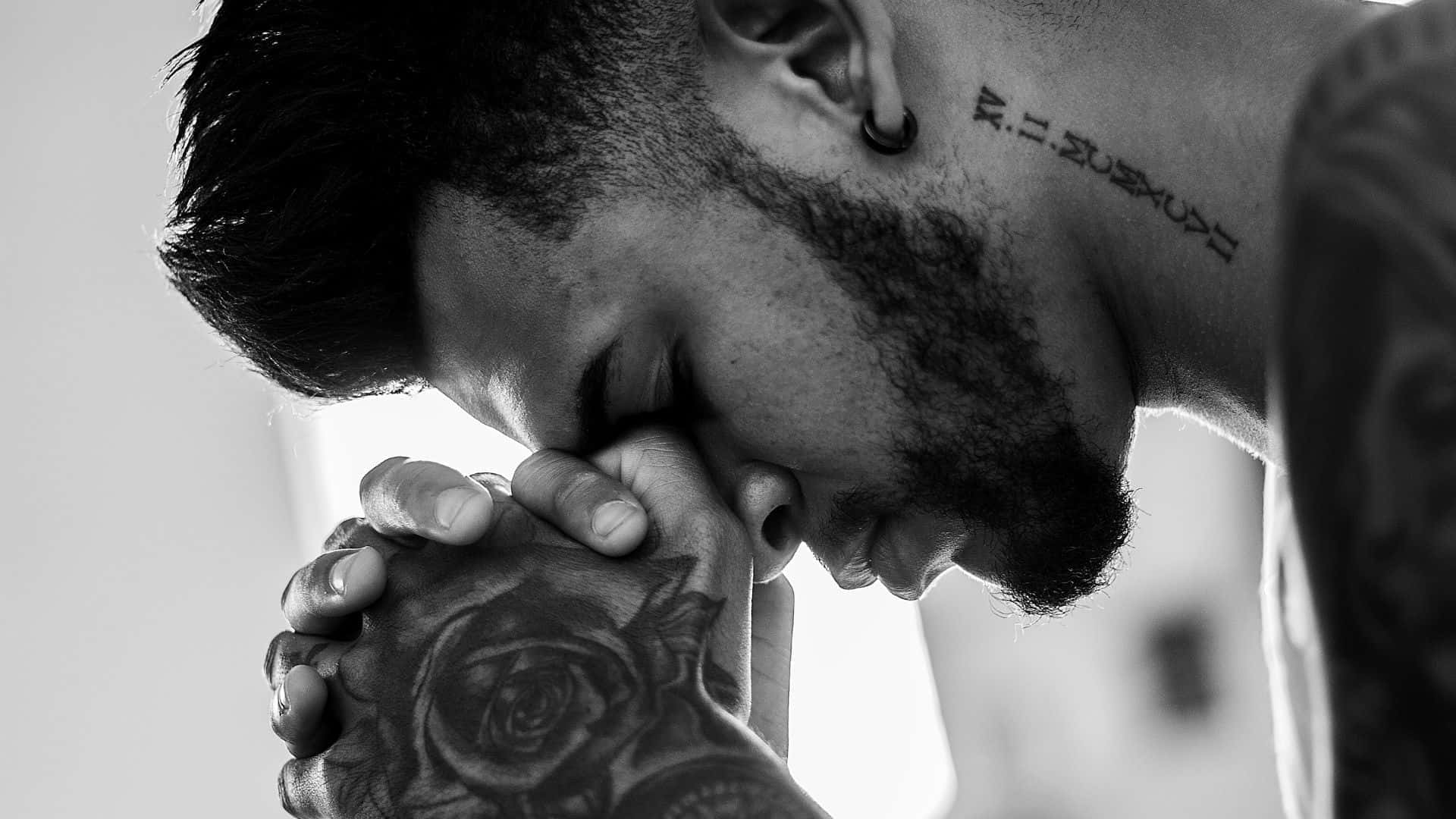 Praying Man With A Hand Tattoo Wallpaper