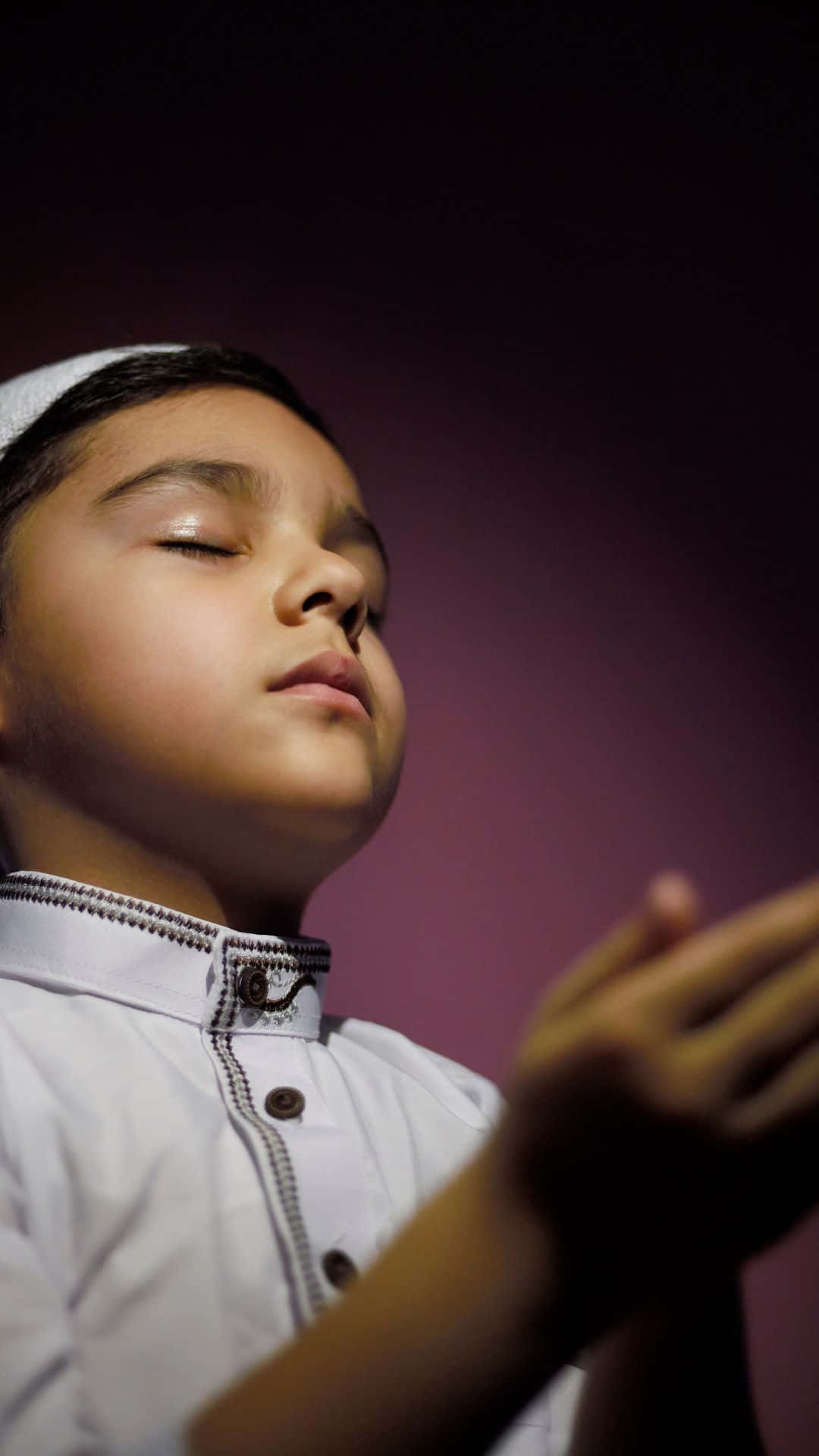 Bedeboende muslimsk dreng mørke violet 8K tapet Wallpaper