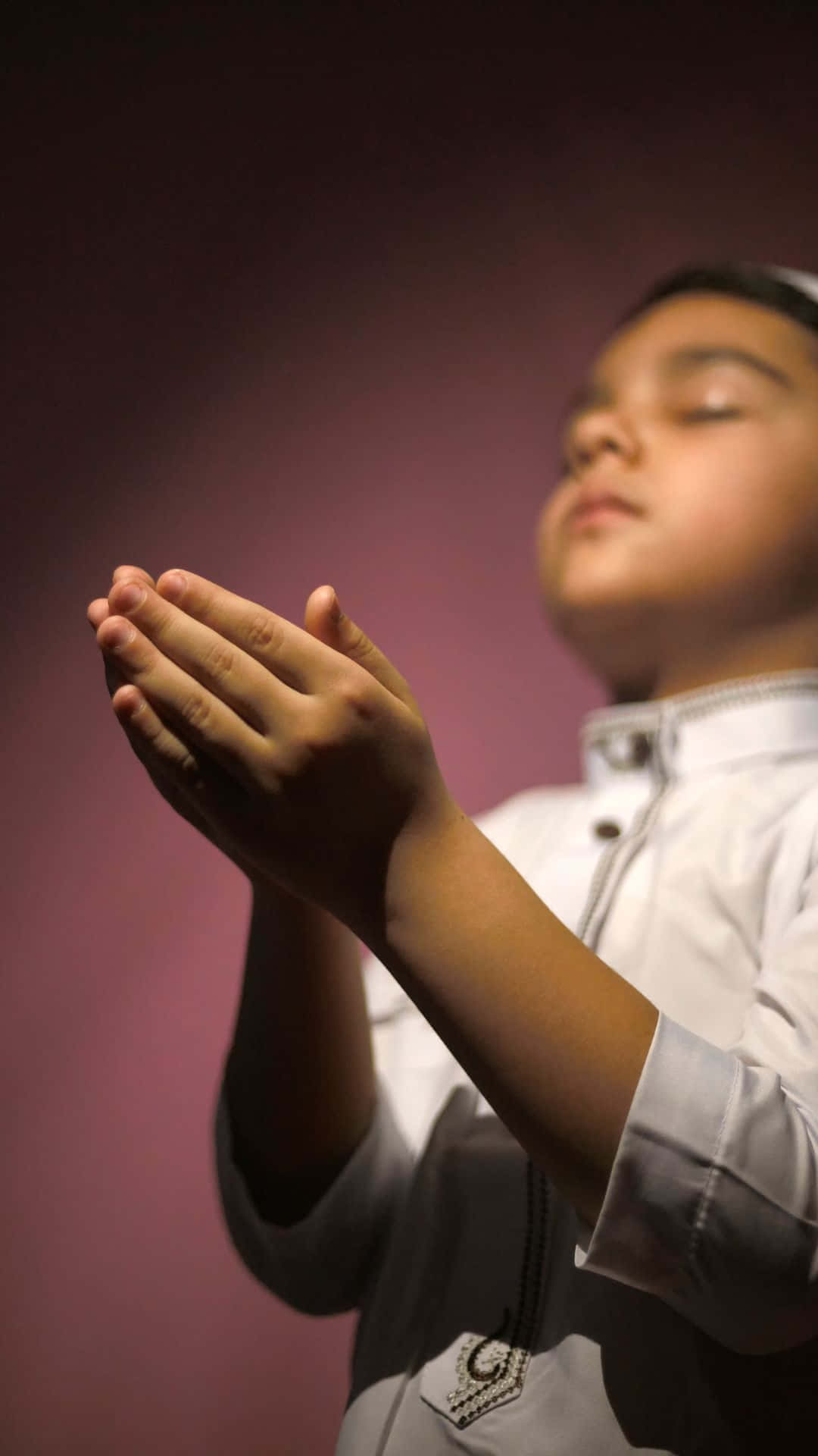 Ritrattodi Un Ragazzo Musulmano In Preghiera Su Sfondo Viola. Sfondo