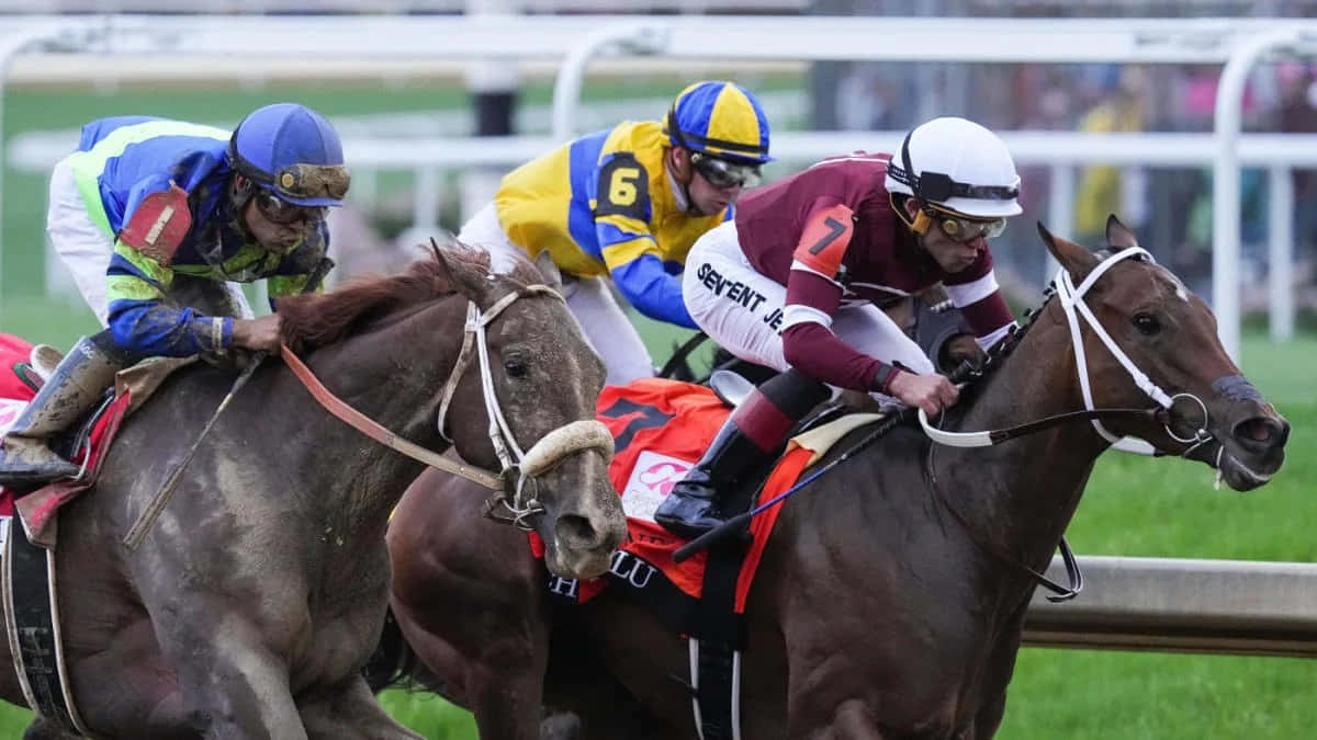 Three Jockeys Are Racing Horses On A Track