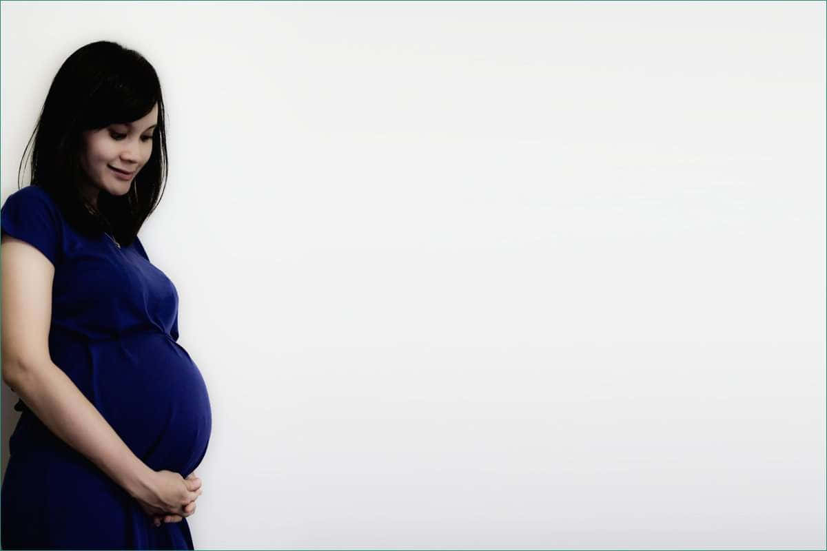 Beautiful serene pregnant woman cradling her belly