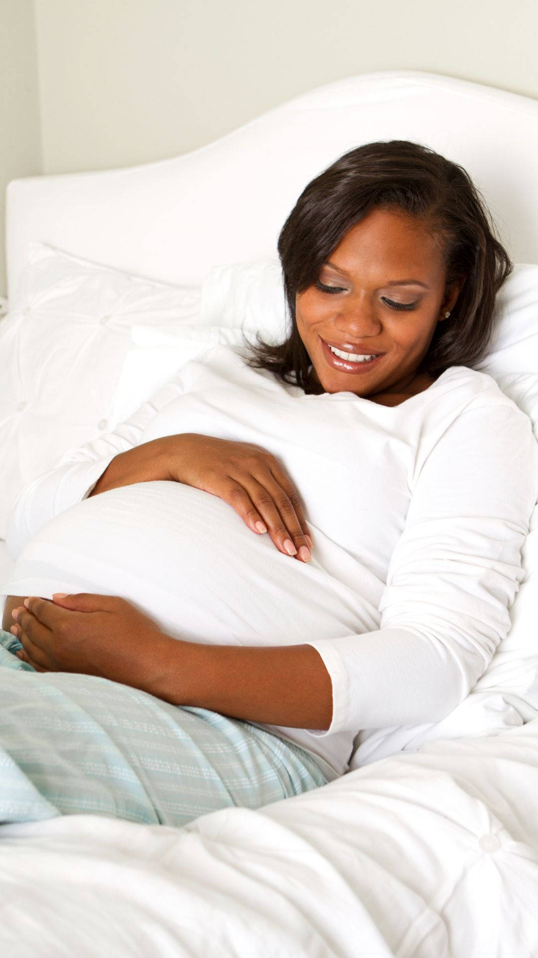 Gravid kvinde ligger på sengen Wallpaper