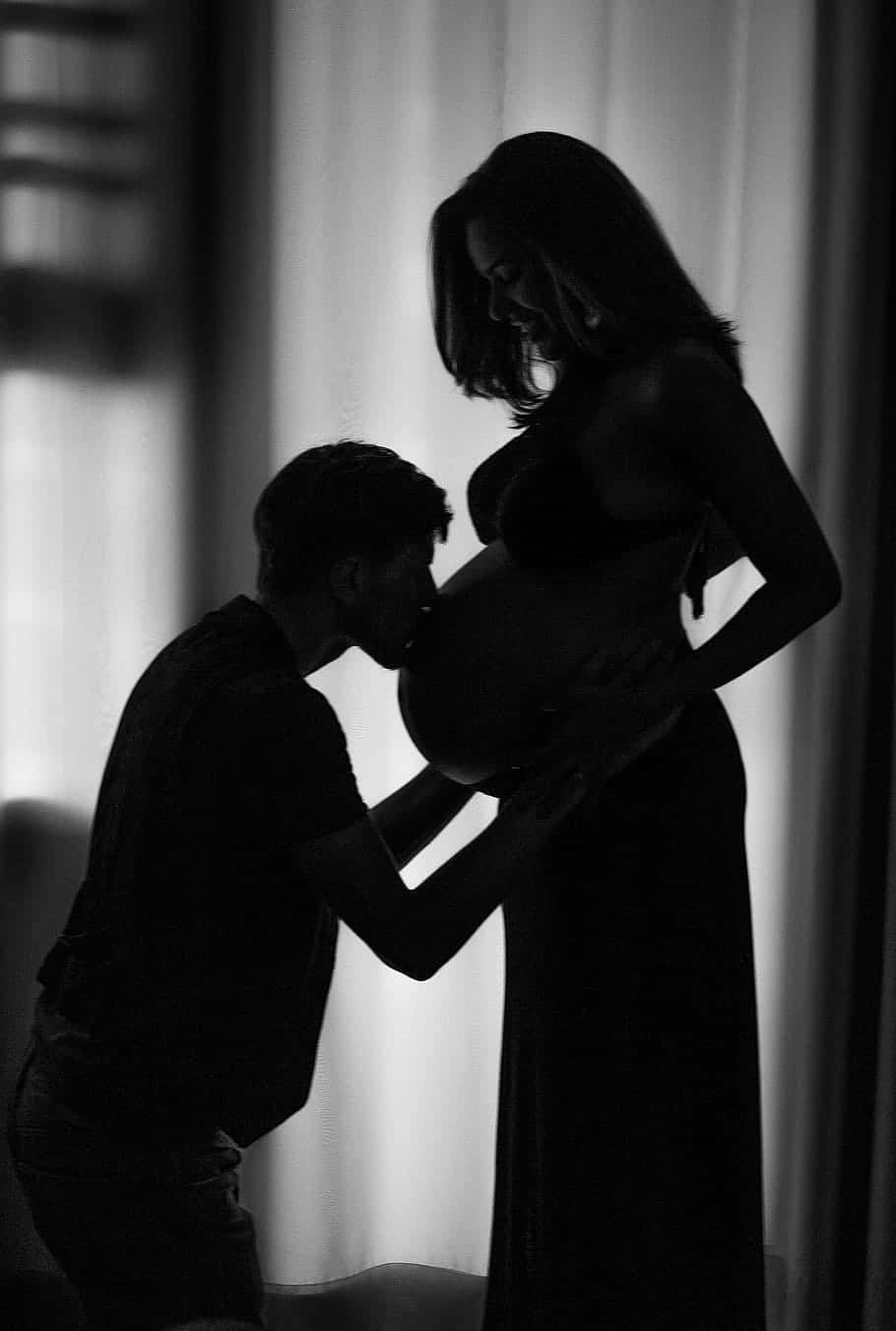 Pregnant Couple Kissing Tummy Silhouette Wallpaper