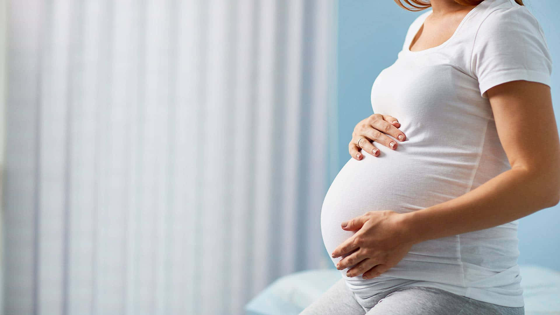 Pregnant Woman Baby Bump Sitting Down Wallpaper