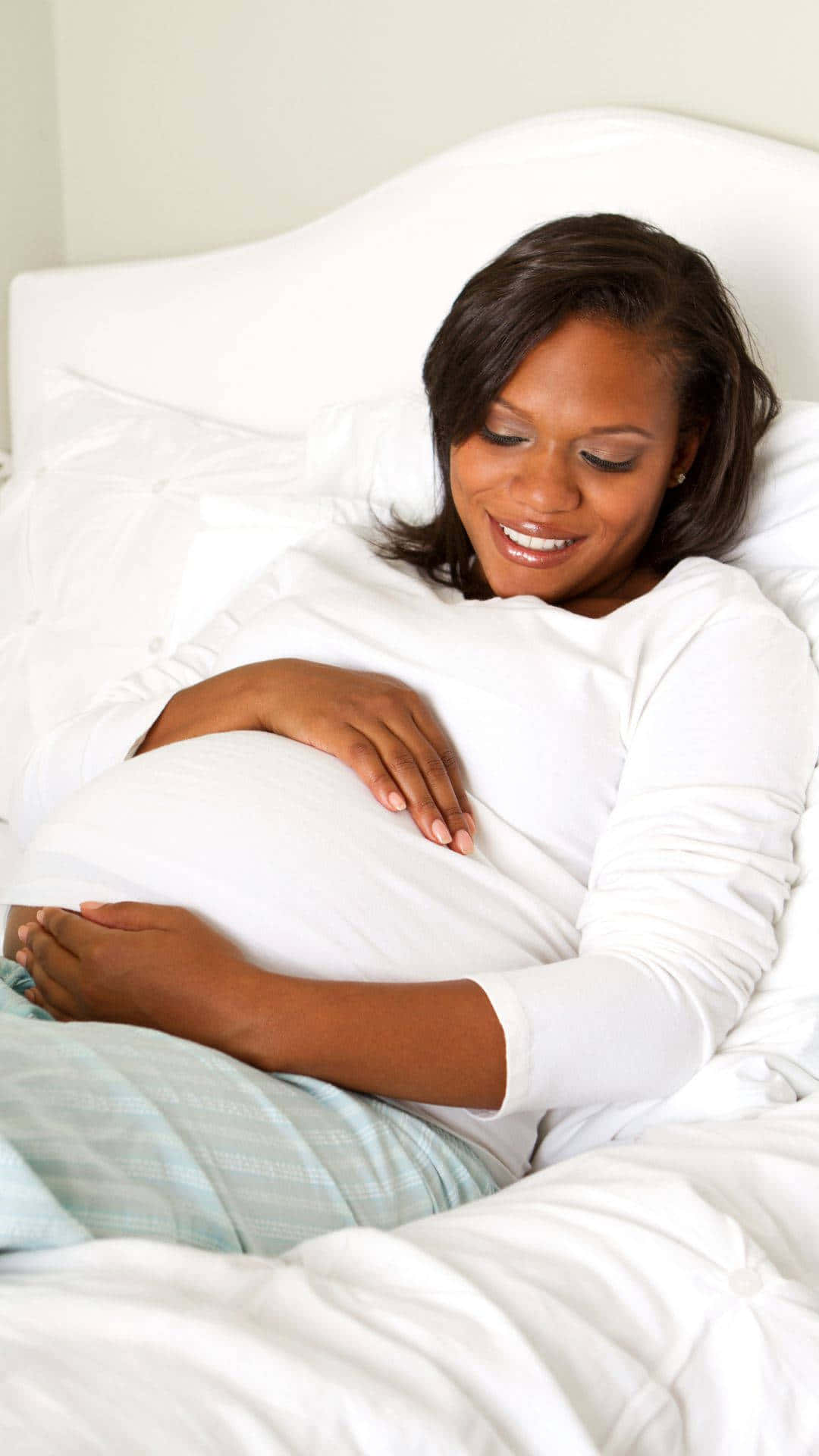 Gravid kvinde ligger i sengen Wallpaper