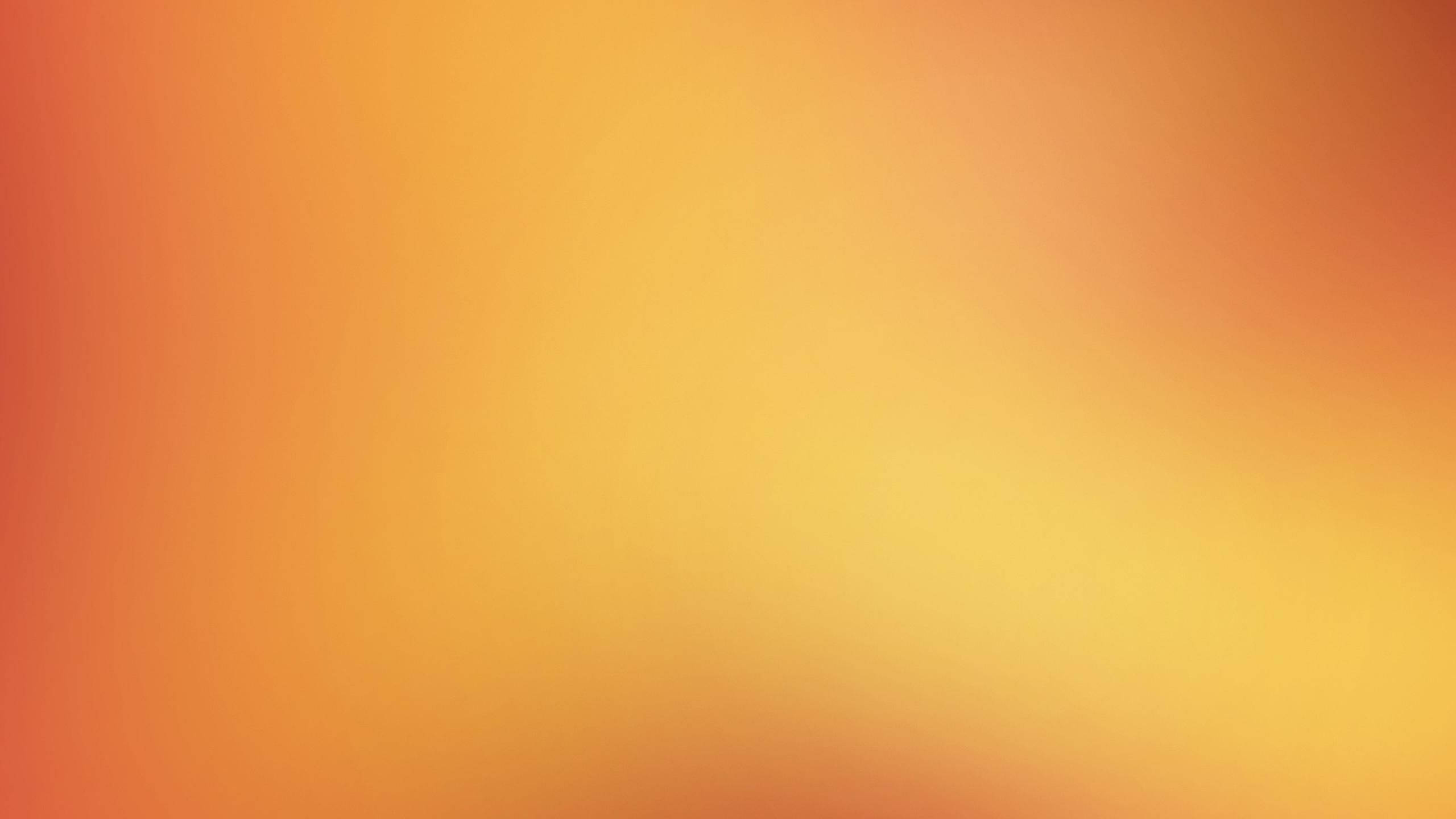 Premium Solid Gradient Orange Wallpaper — A smooth gradient of warm orange and yellow tones creating a soft glowing background.