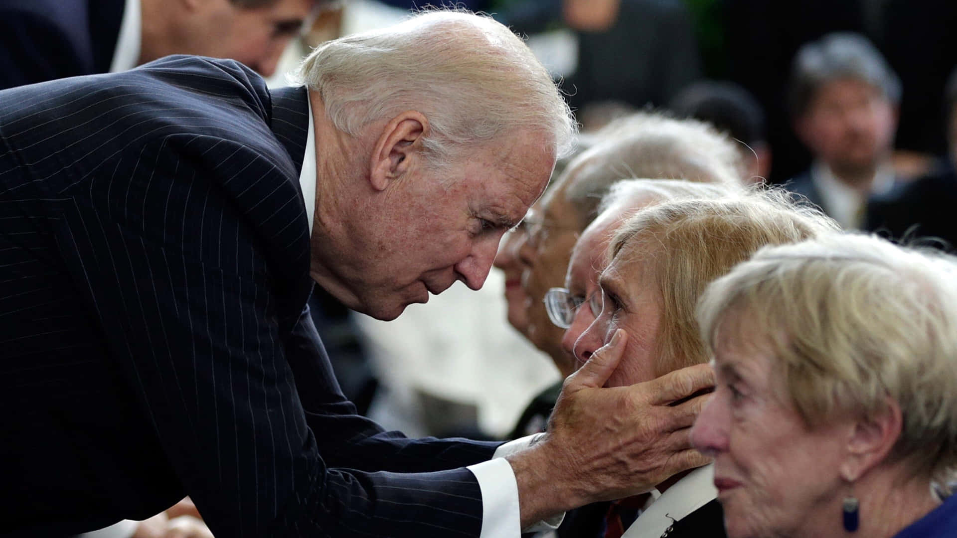 President Biden Comforting An Old Lady Wallpaper