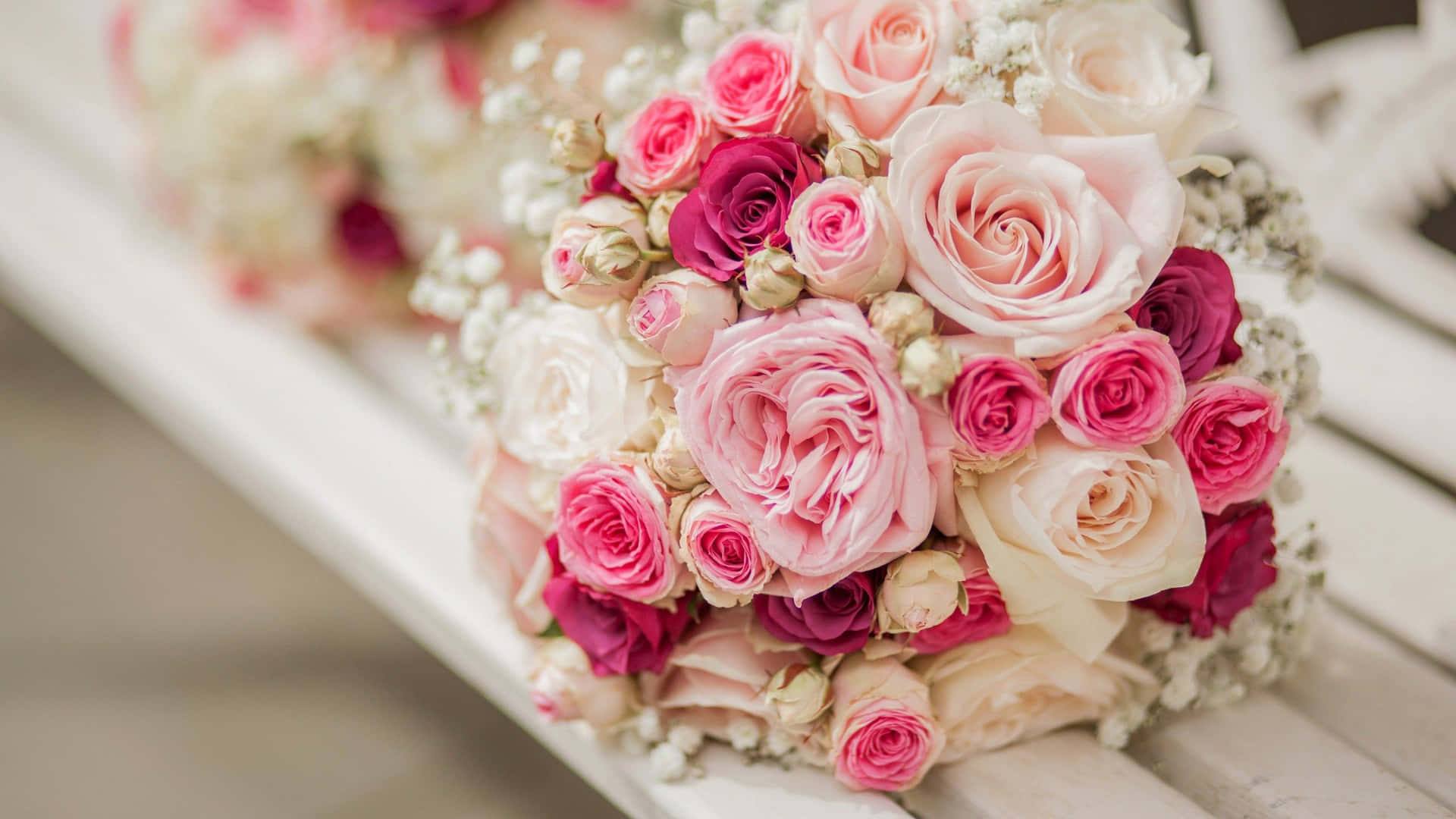 a bouquet of pink and white roses is sitting on a bench