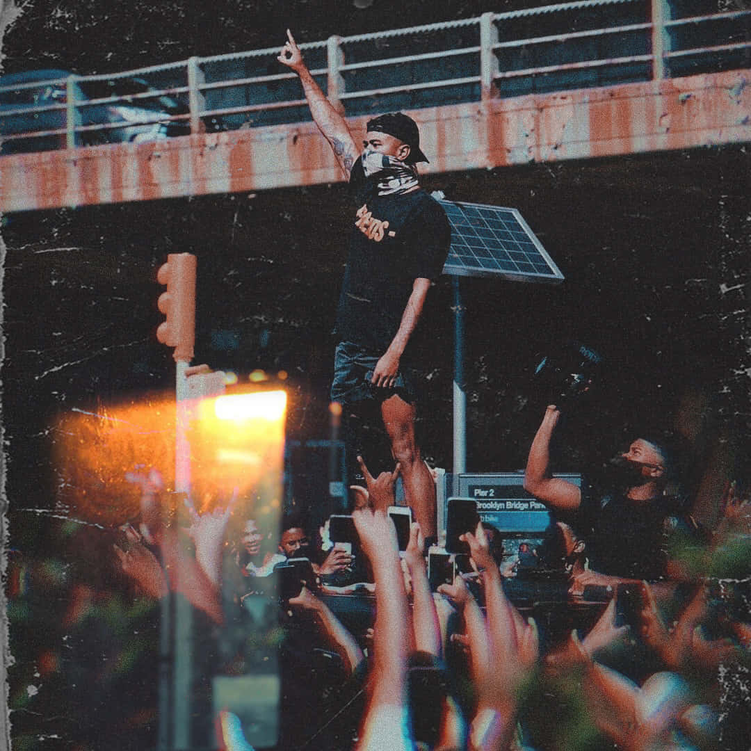 A Man Is Standing On Top Of A Crowd Of People Wallpaper