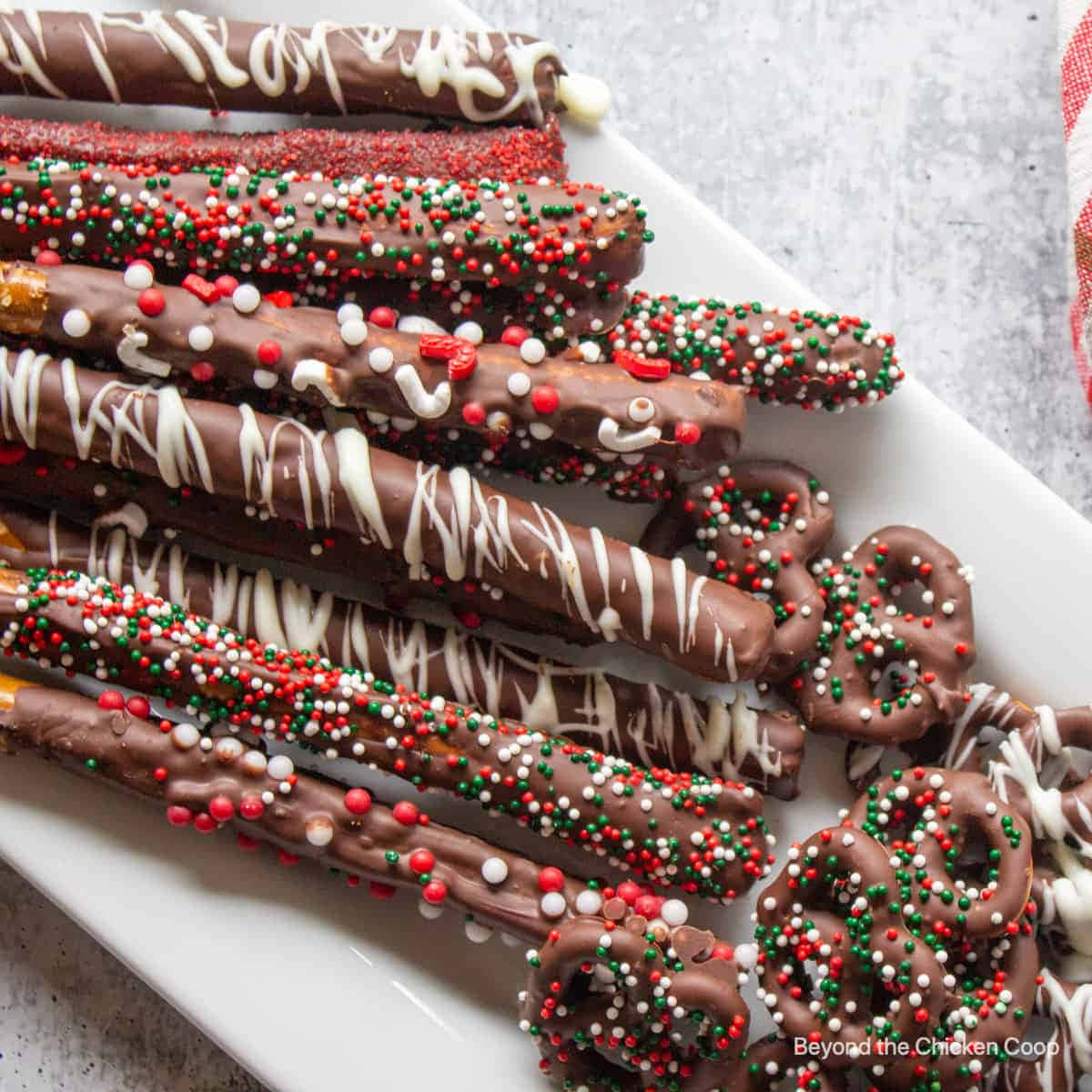 Chocolate Pretzel Sticks With Sprinkles On A White Plate