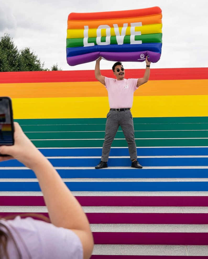 Man Carrying Inflated Pride Flag Picture
